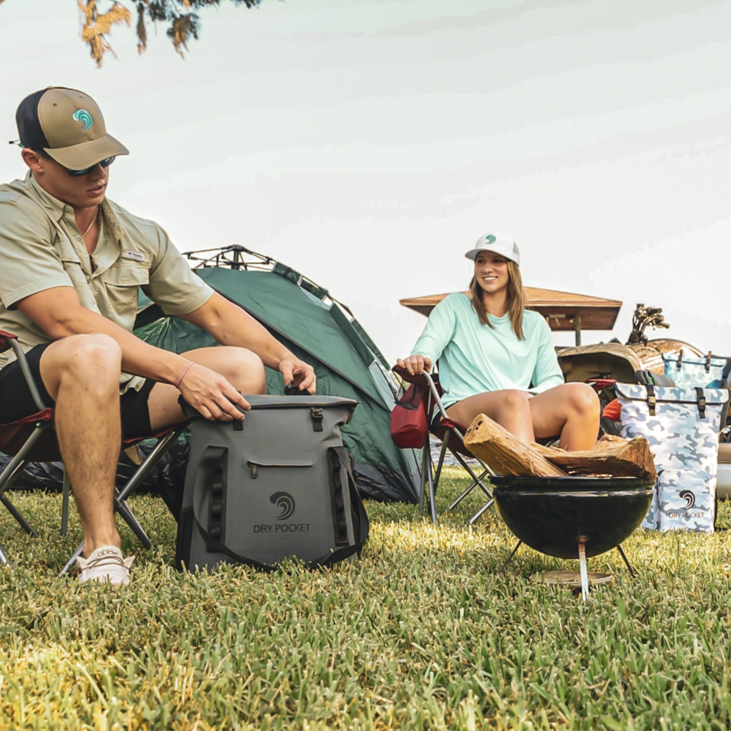 Waterproof floating tote cooler on grass, dark gray with DRY POCKET logo and front latch