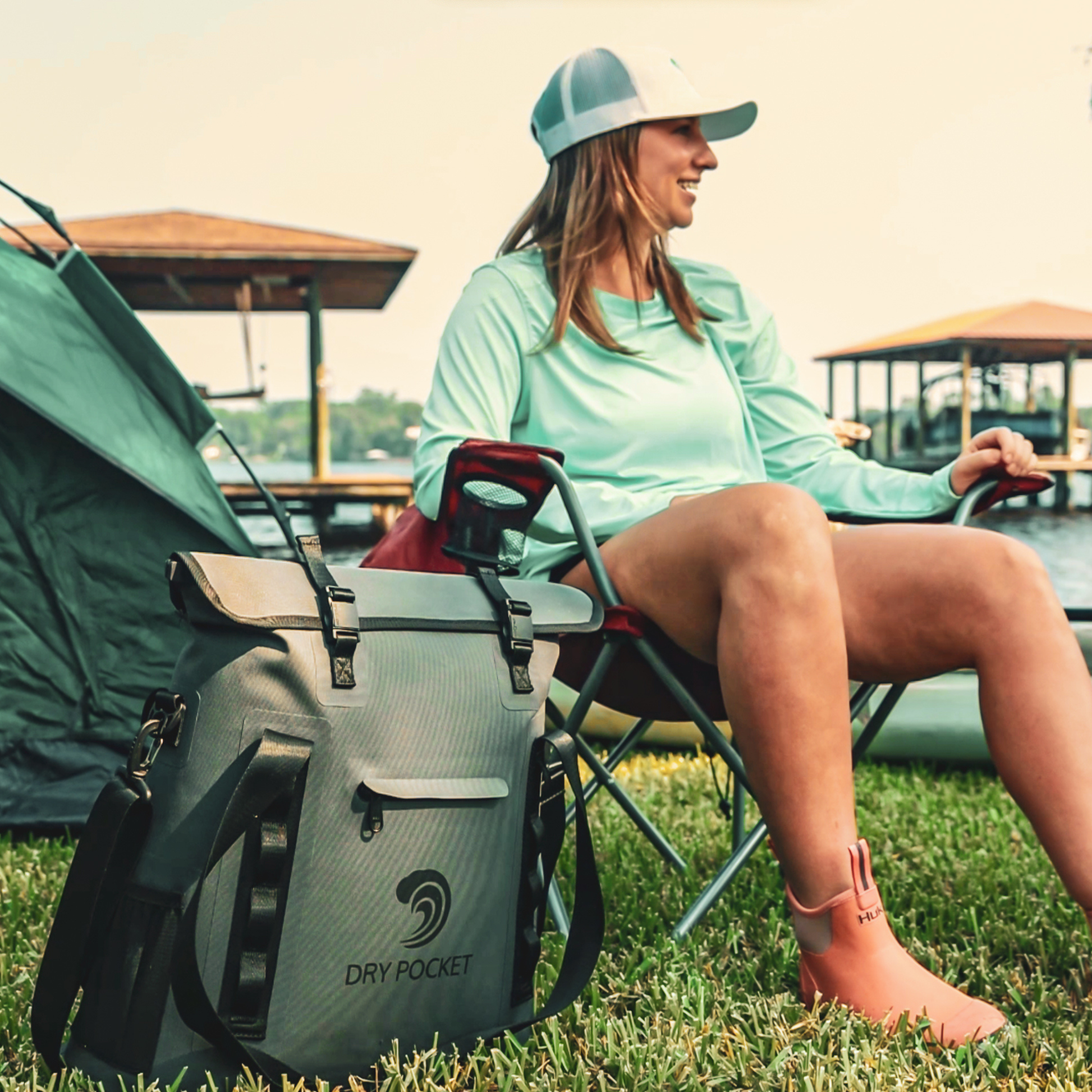 Waterproof floating tote cooler side view, dark gray with adjustable shoulder straps and logo