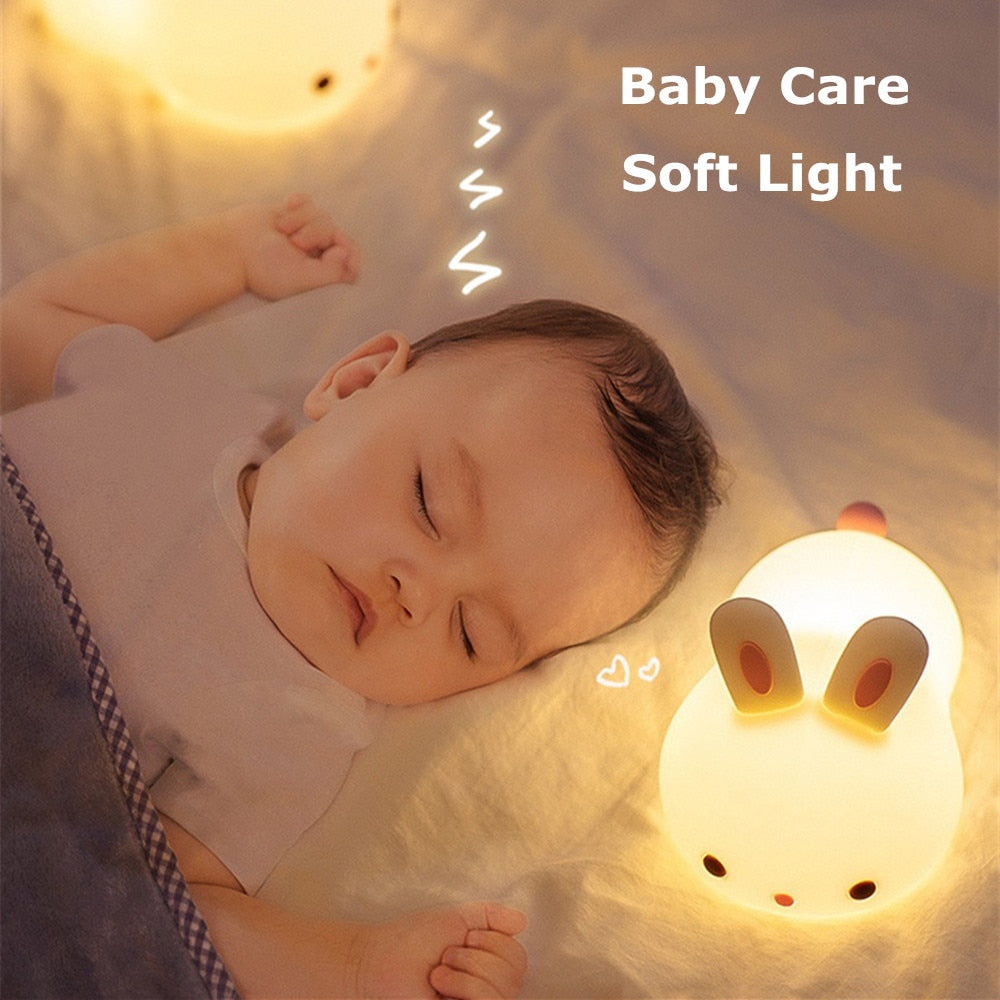 Bunny night light next to a sleeping baby, warm soft glow from the base