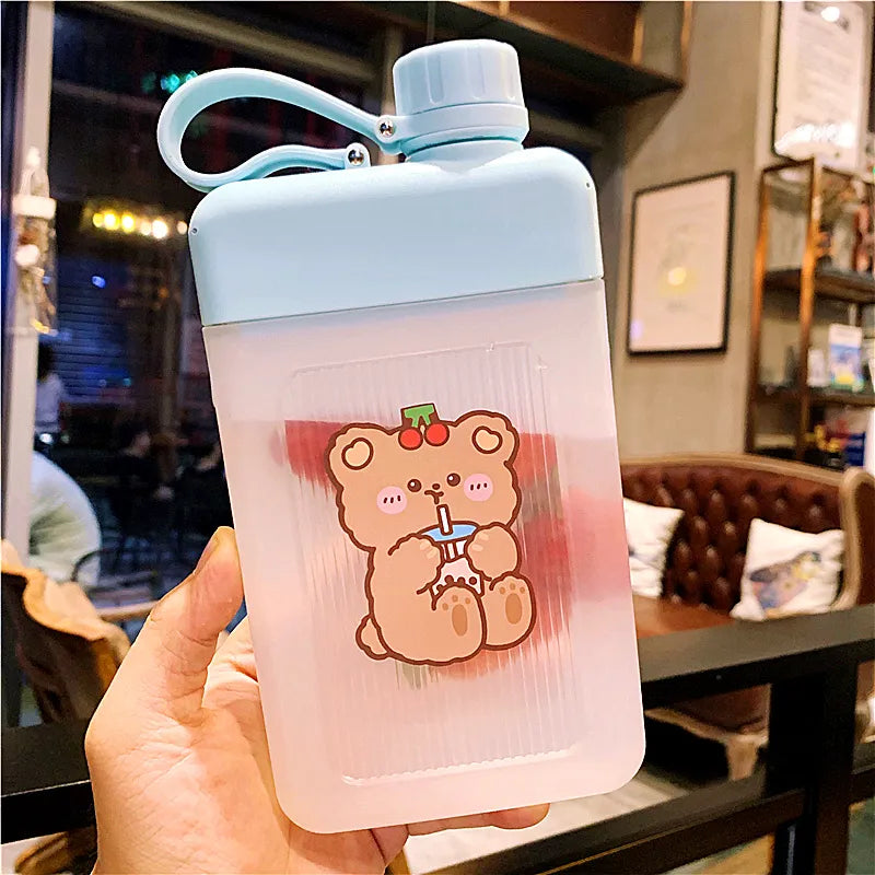 White flat water bottle with bear cartoon sticker, blue carry loop handle and flip lid