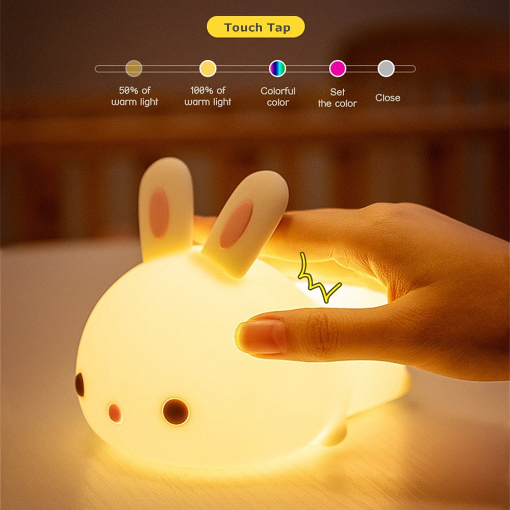 Touch-tap bunny night light with hand near glowing ears and adjustable light
