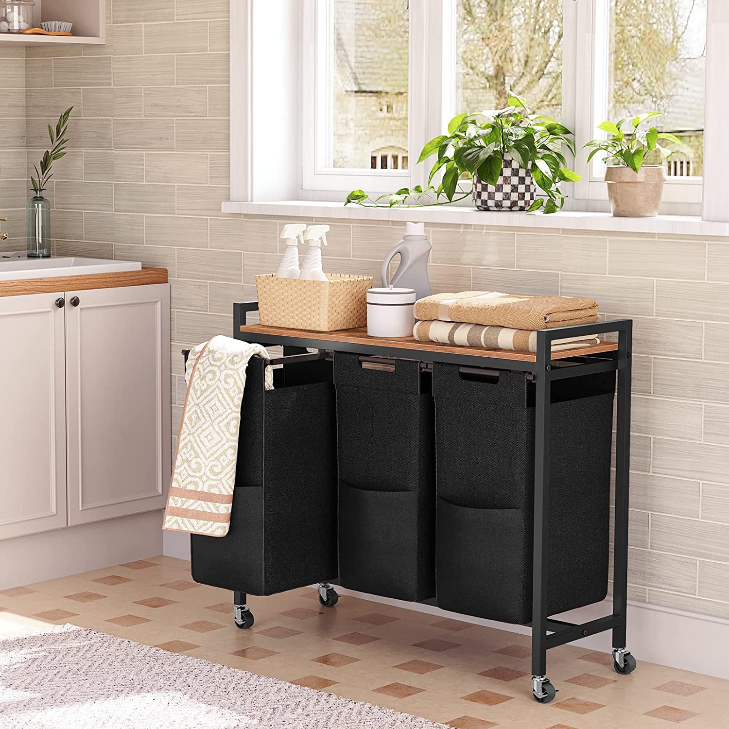 Rolling 3-compartment laundry hamper cart with black fabric bins and wooden top shelf.