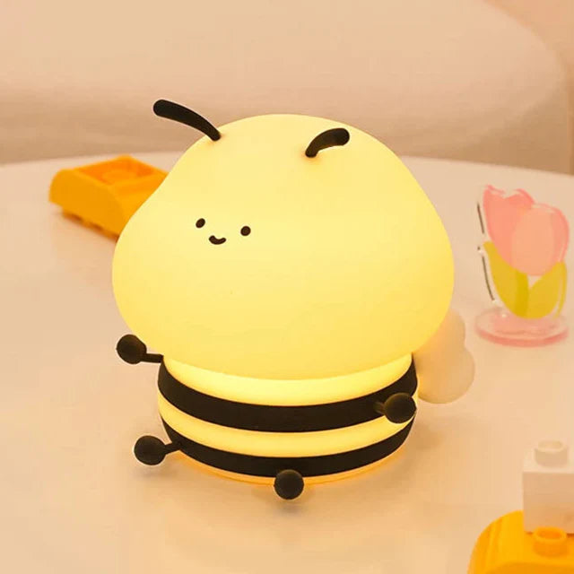 Bee-shaped night light with a smiling face, yellow glow, and three black striped rings
