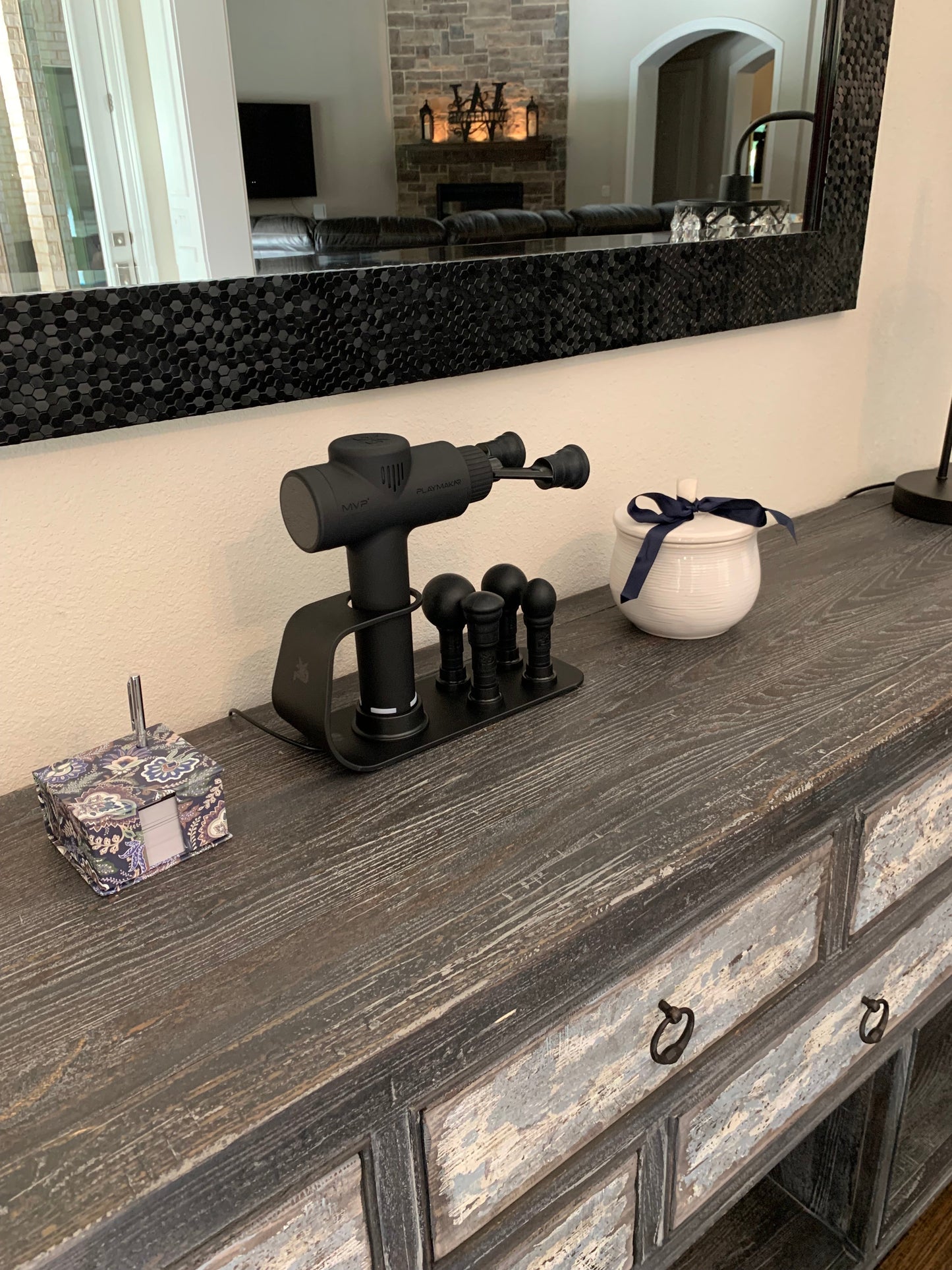 Black massage charging station with four heads on a bathroom vanity shelf