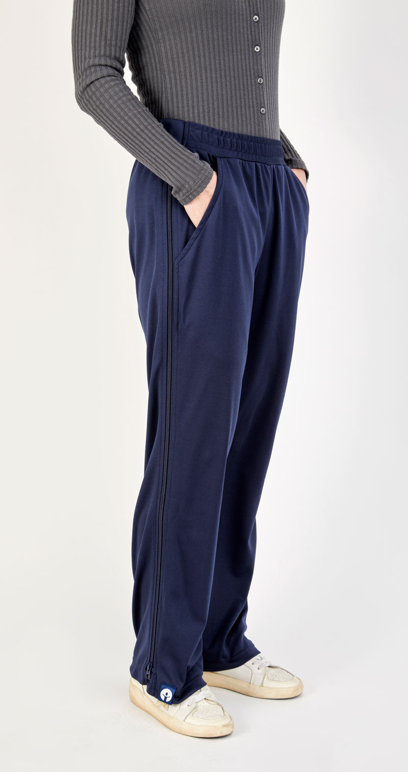 Person wearing navy pants and a gray sweater on a white background