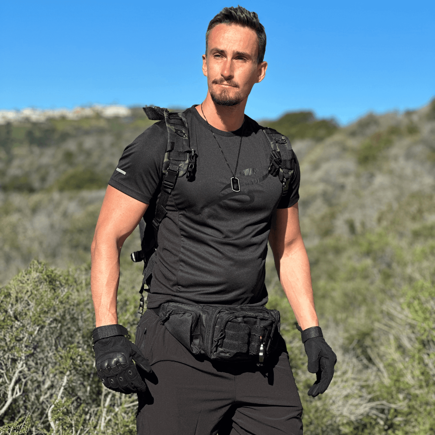 Black tactical gloves with textured grip, molded knuckle padding, and elastic wrist cuffs