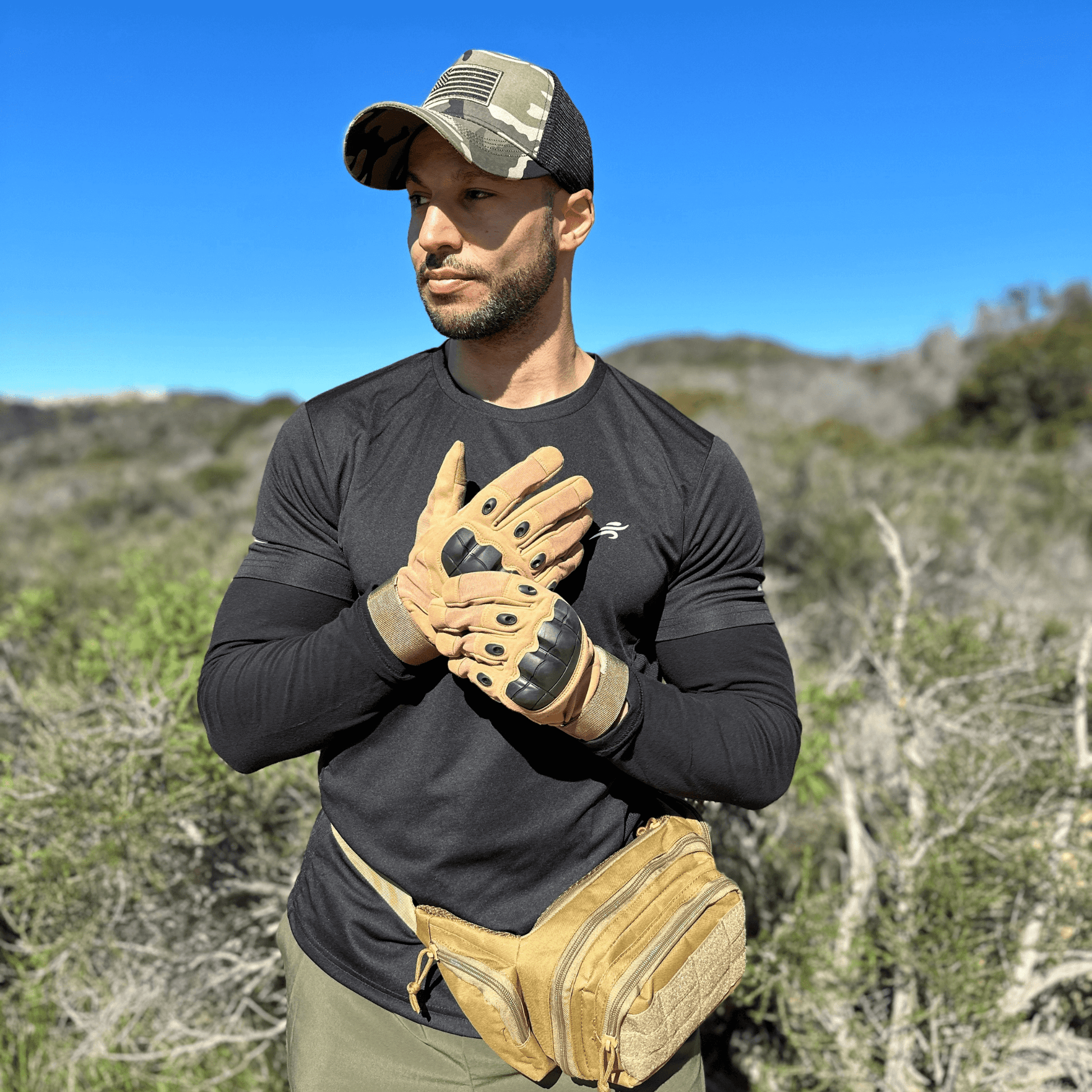 Tan tactical gloves worn by a person, showing knuckle armor and padded palms