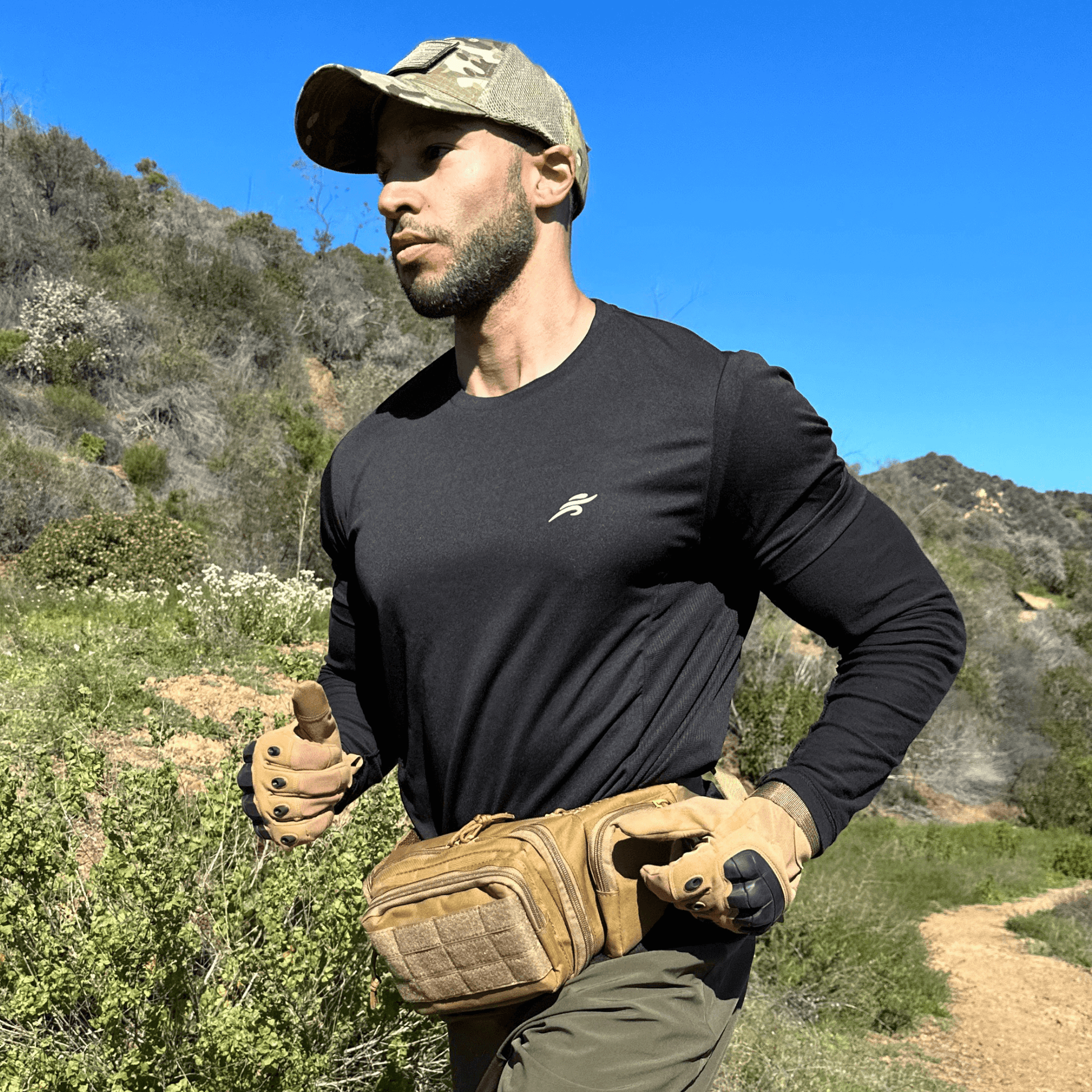 Tan tactical gloves worn by a person, showing armored knuckles and straps