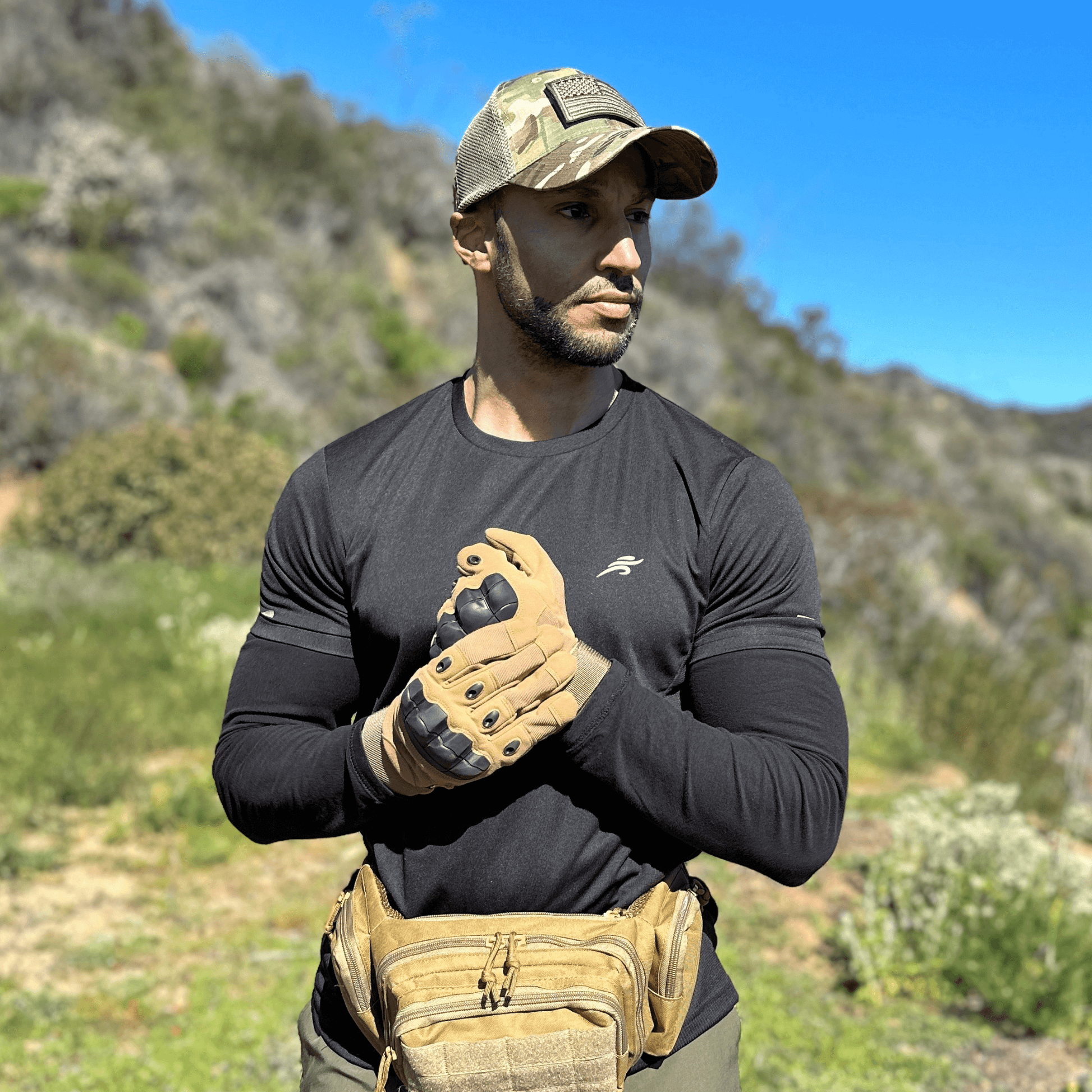 Tan tactical gloves worn by a person with touchscreen fingertip pads visible