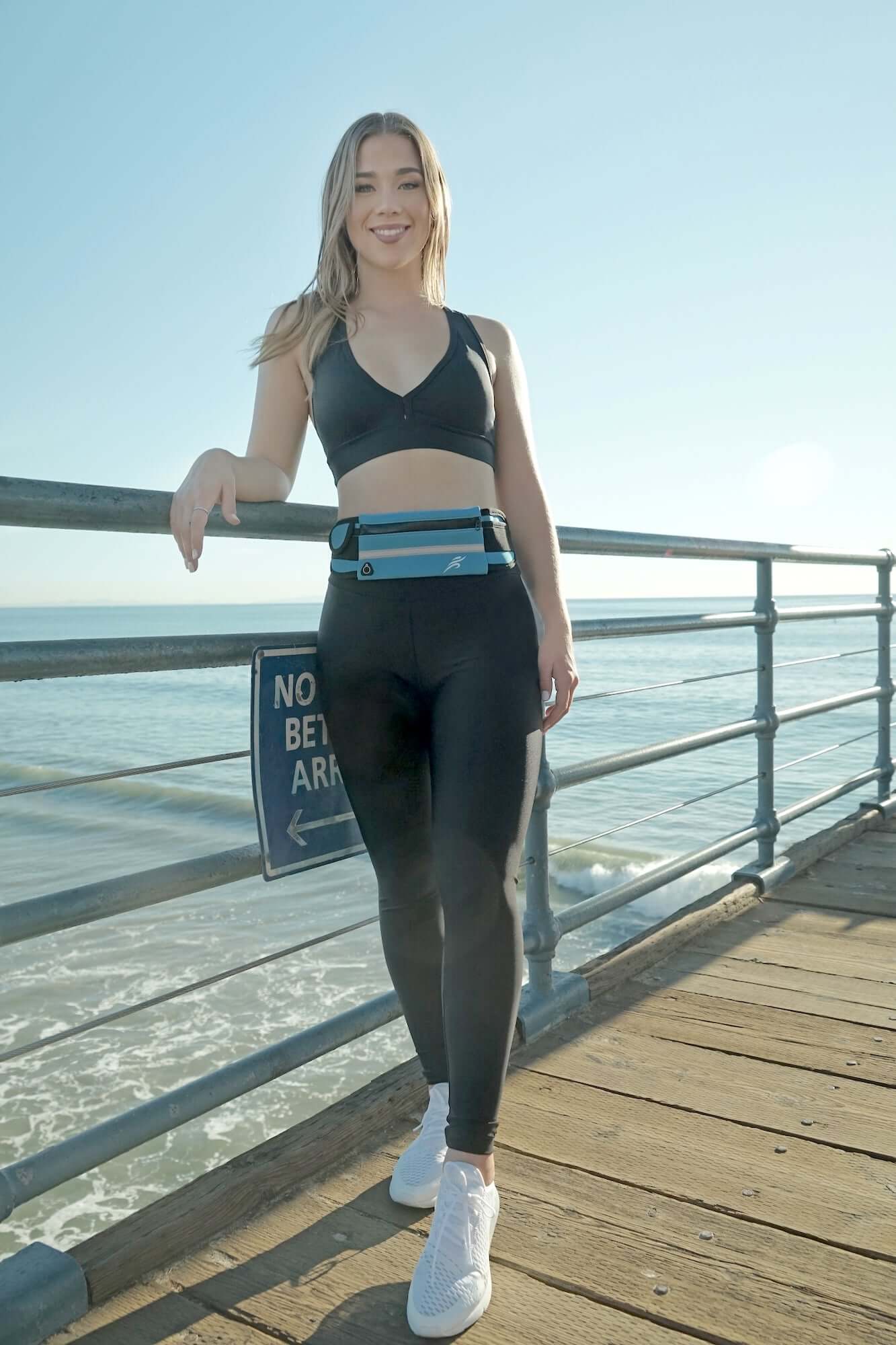 Blue sports running belt fanny pack worn on waist with front pouch and buckle
