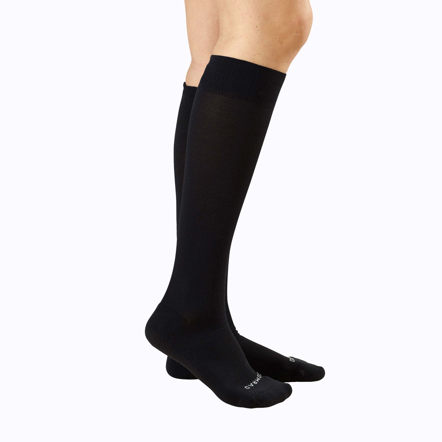 Knee-high compression socks in black on legs, seamless look with cushioned foot