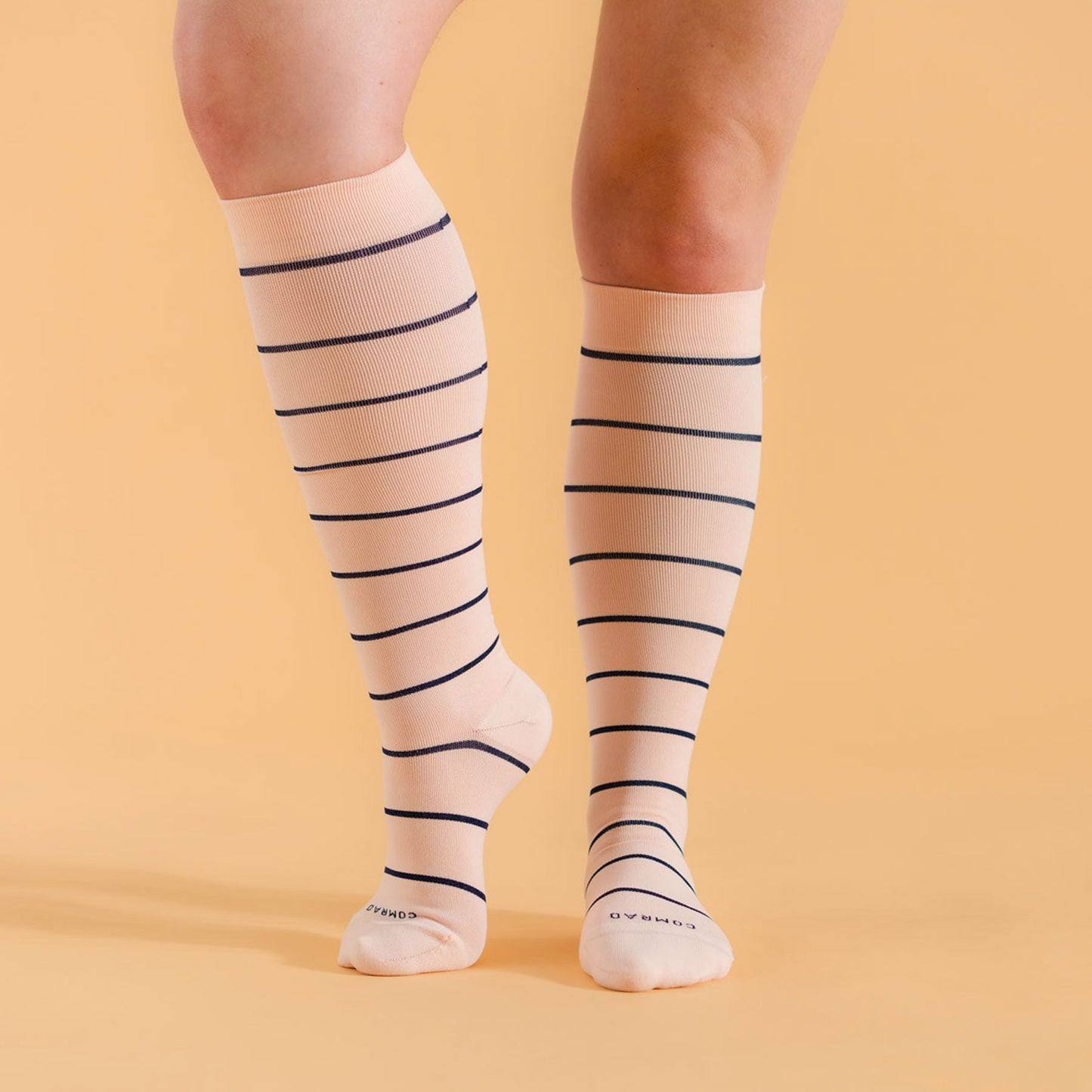 Pair of knee-high compression socks in pale rose with navy horizontal stripes