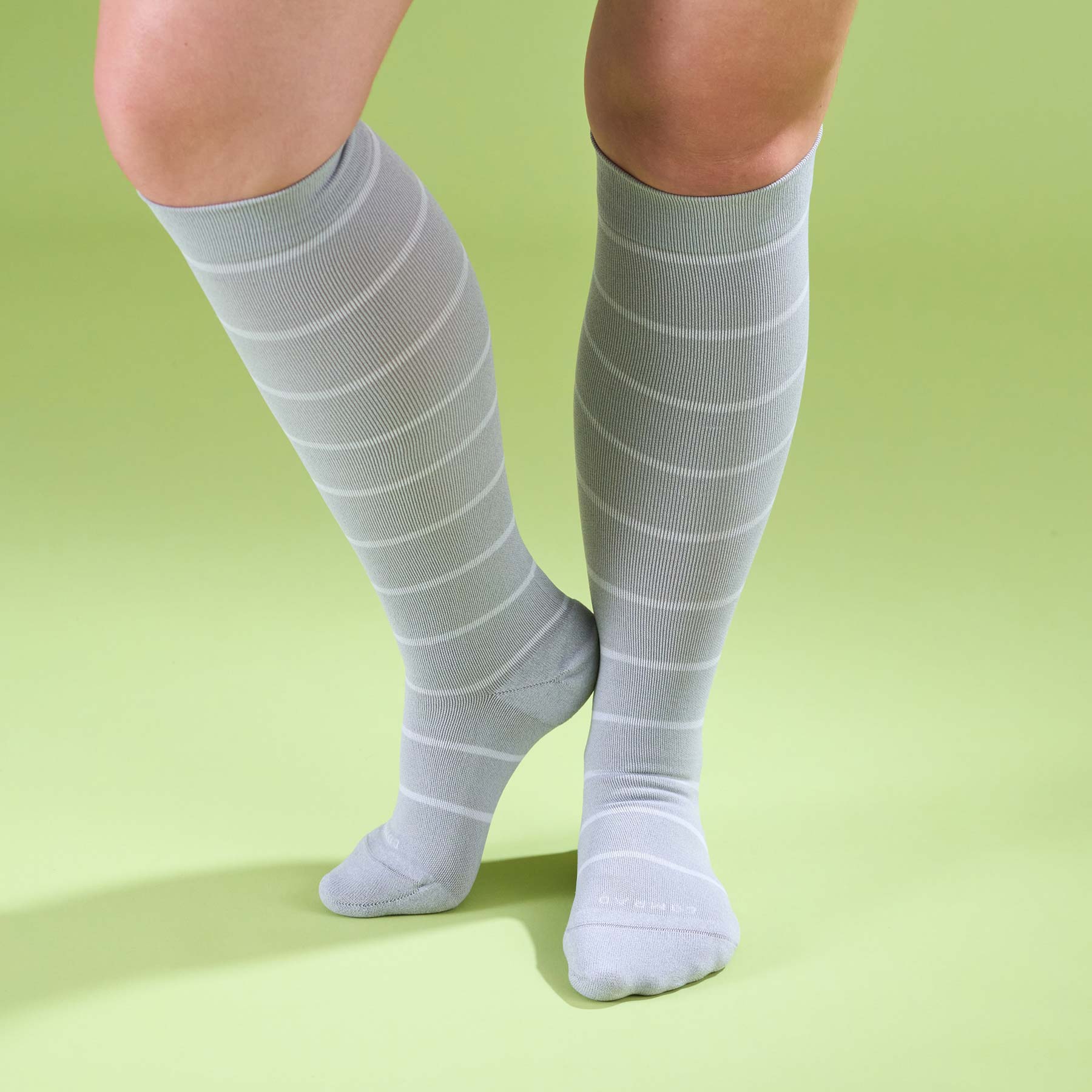 Heather gray knee-high compression socks with horizontal stripes worn on legs