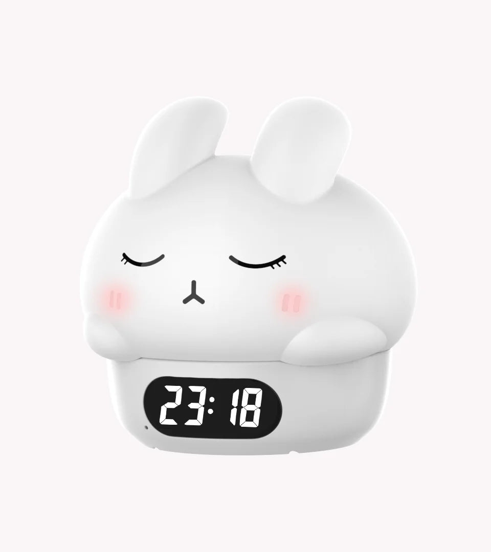 White bunny alarm clock with closed eyes and 23:18 LED digital display.