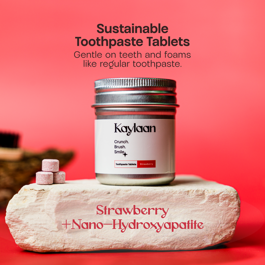 Non-fluoride strawberry toothpaste tablets jar with tablet pieces on stone
