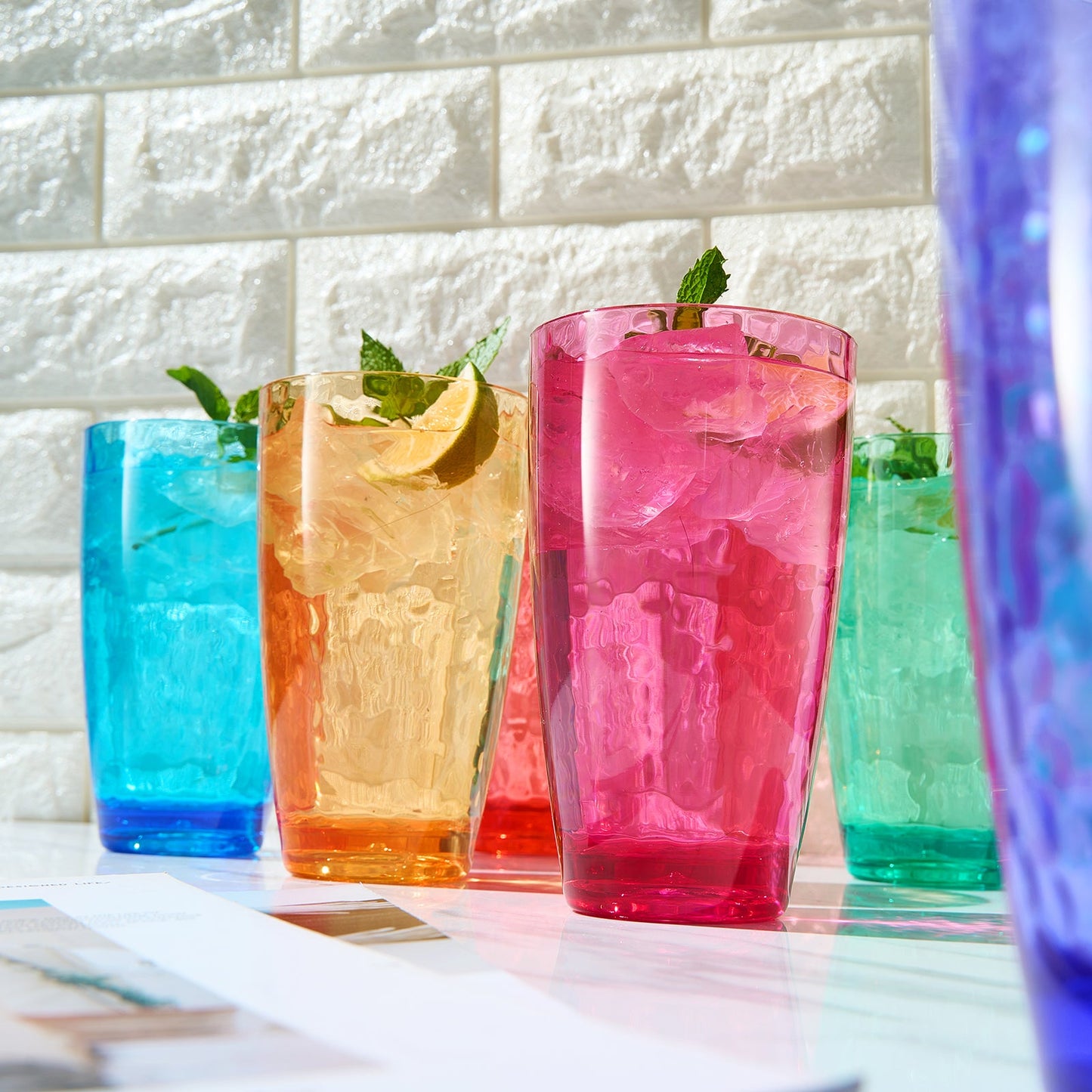 Set of 6 colored acrylic highball glasses with ice and mint, with citrus slices