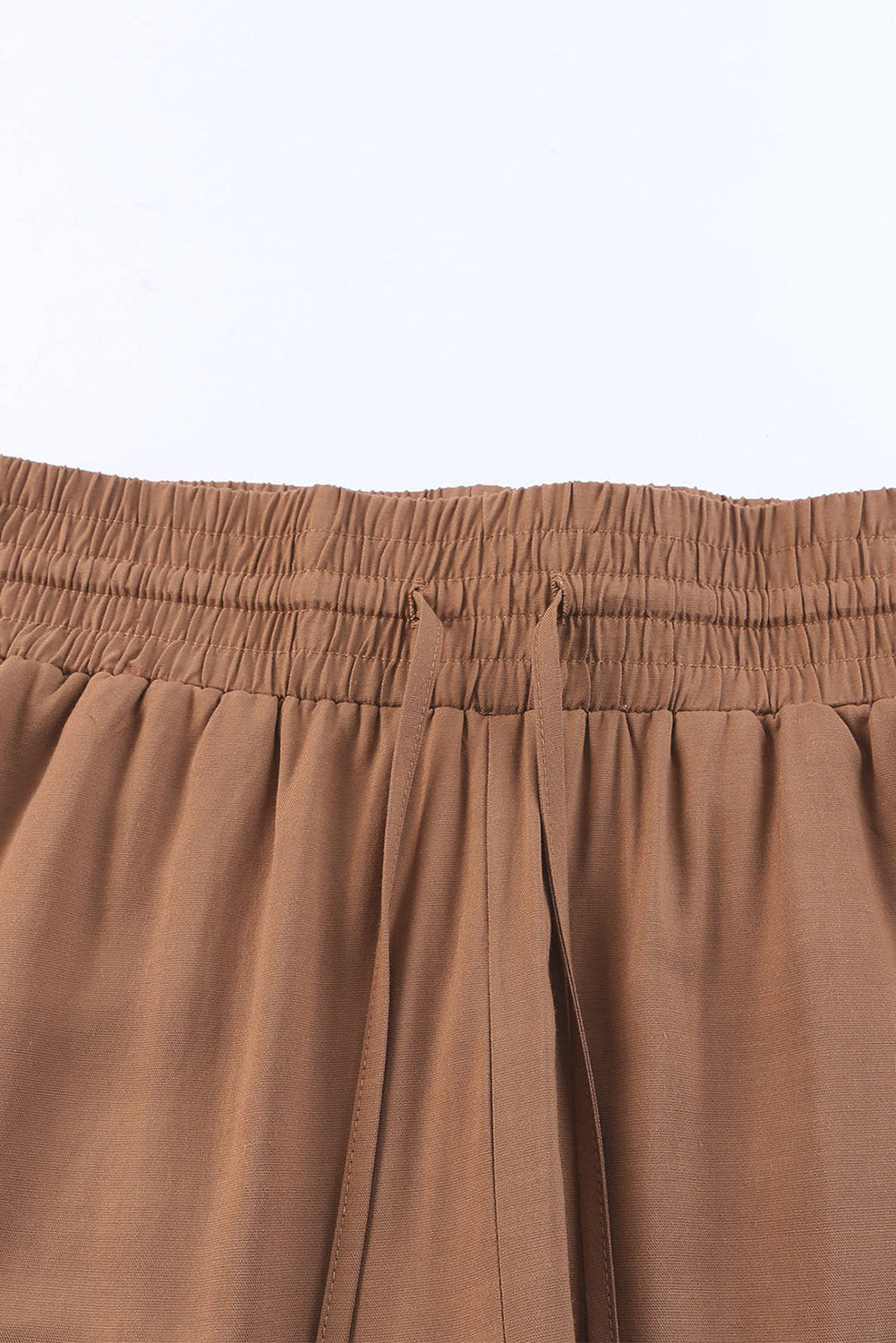 Tan pants waist with elastic band and drawstring cord detail