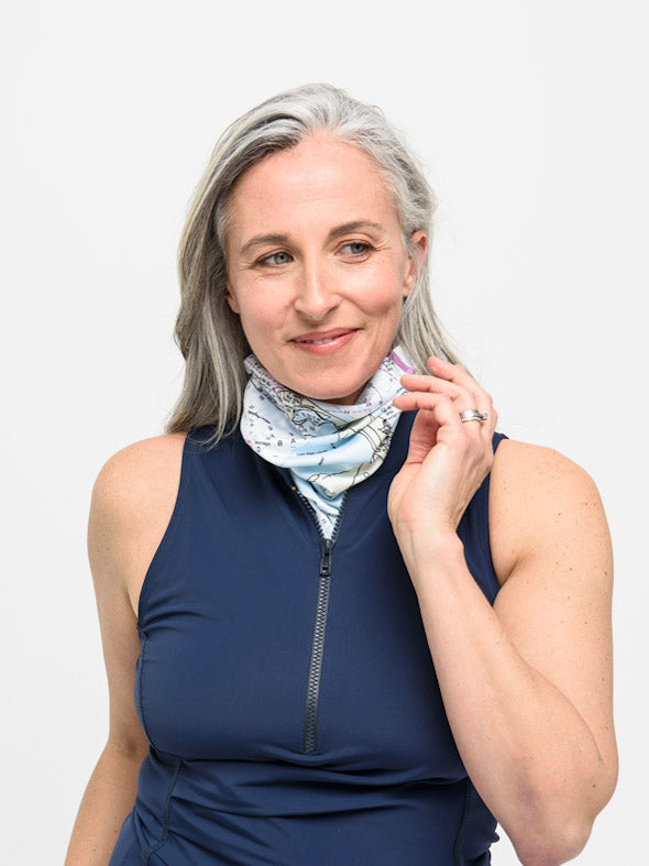 Solar gaiter with white nautical map print, worn around woman’s neck