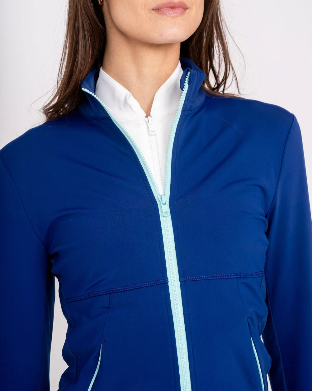Blue full-zip jacket close-up: stand collar and white zipper with contrast piping
