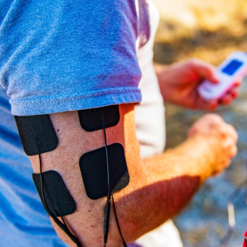 Black electrode pads with thin cables applied along the forearm