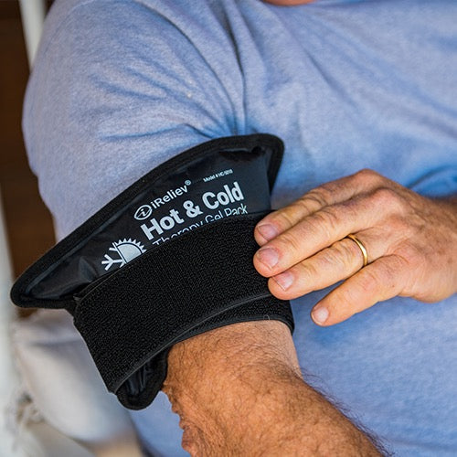 Black Hot & Cold therapy gel pack with strap tab, close-up on textured fabric