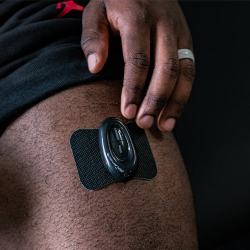Wireless TENS controller with adhesive electrode pad, placed on skin