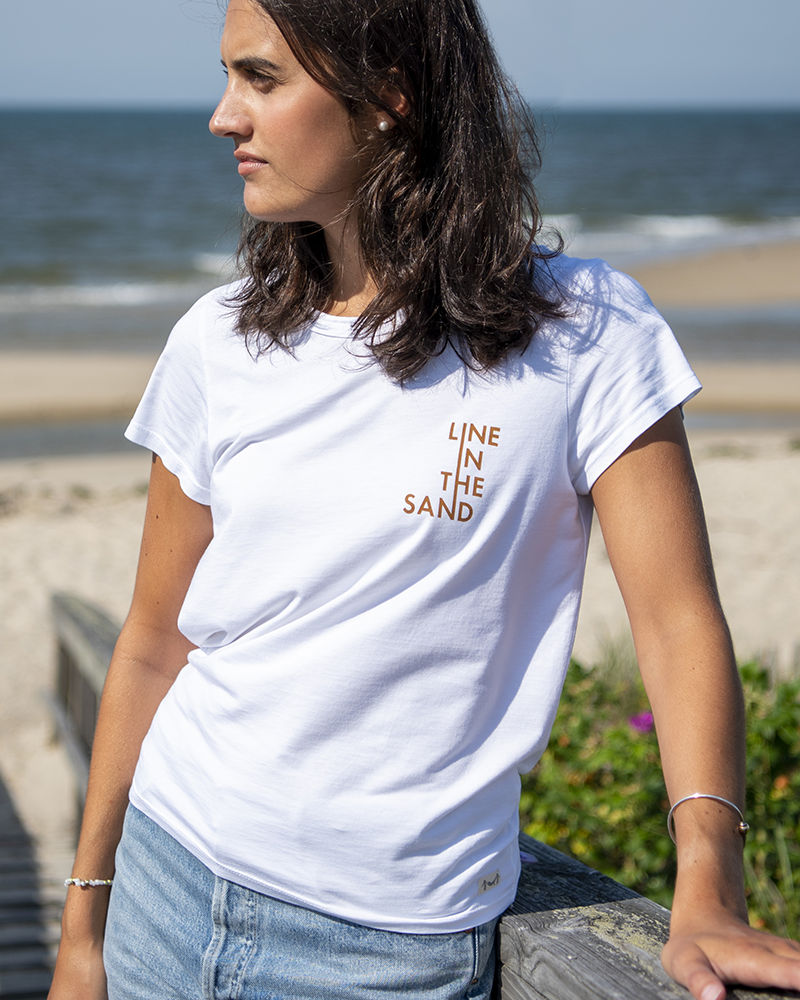 White crew-neck graphic tee with orange 'LINE IN THE SAND' chest text and short sleeves