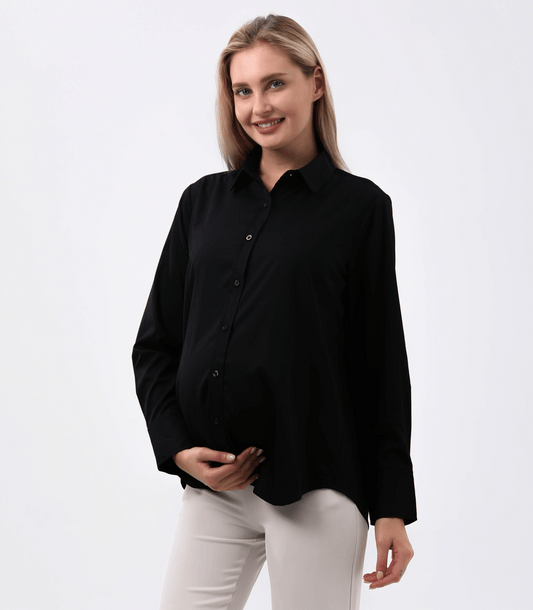 Woman wearing a black shirt and white pants on a plain background