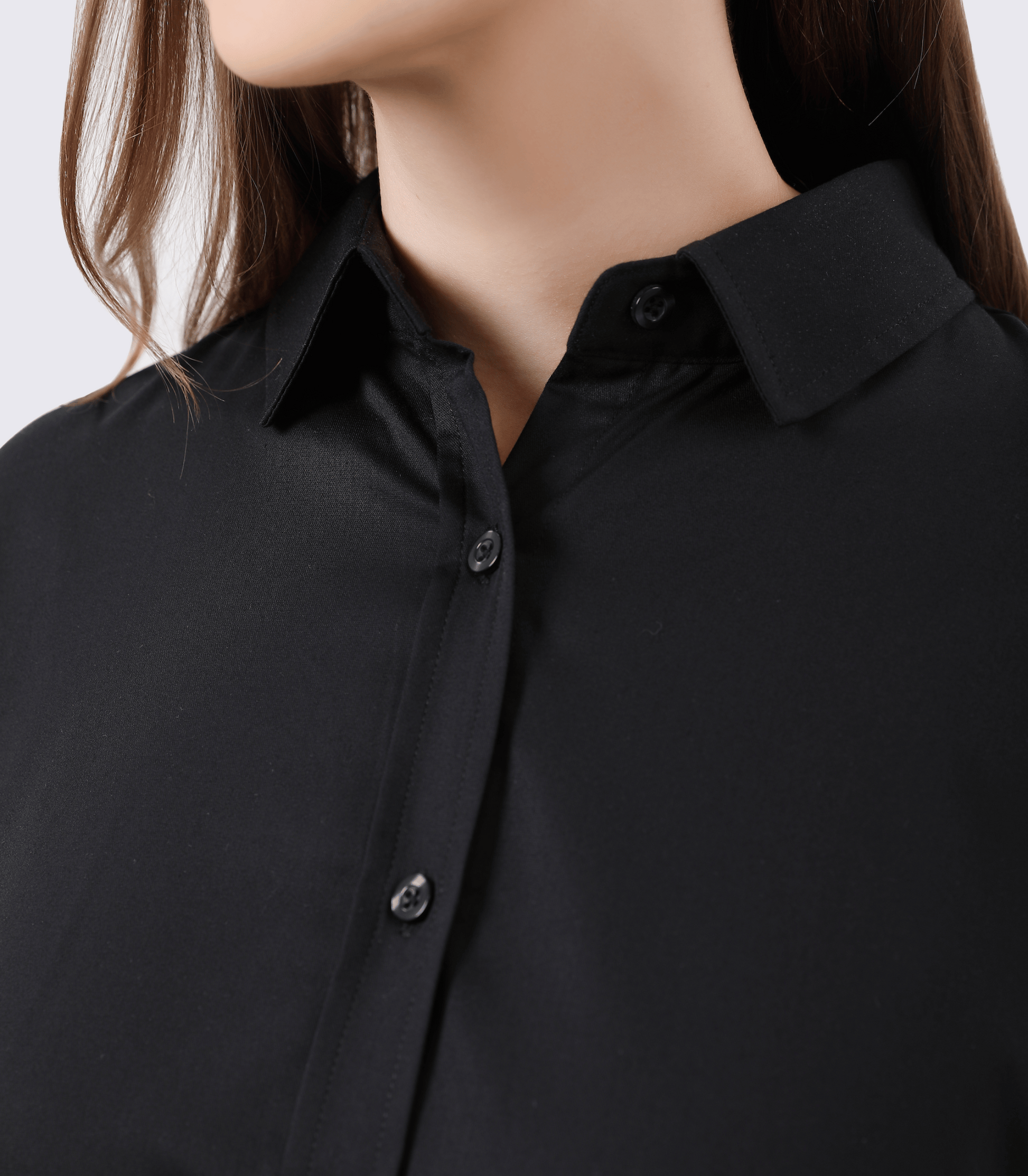 Close-up of a person wearing a black button-up shirt against a neutral background