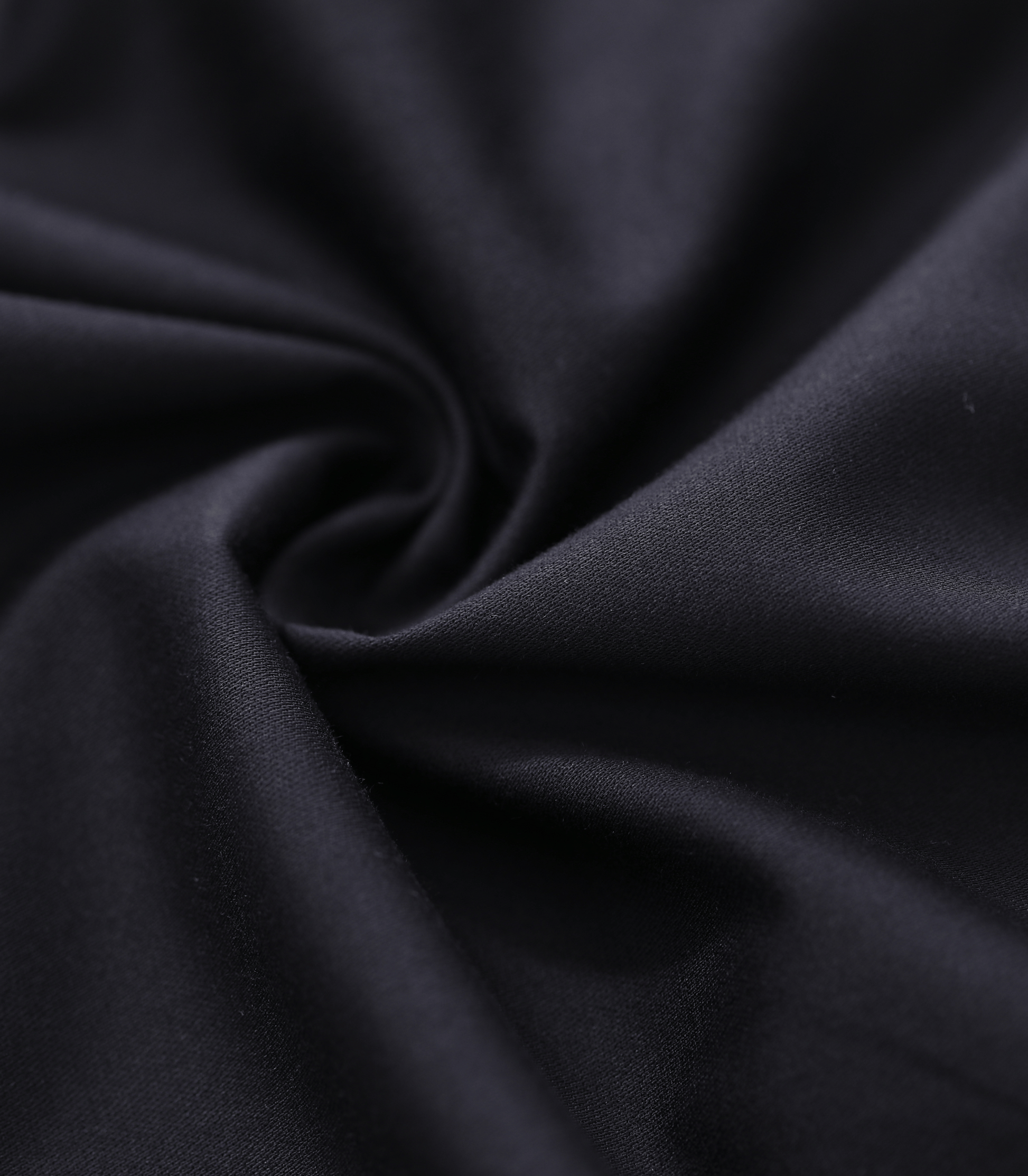 Close-up of dark black fabric with folds
