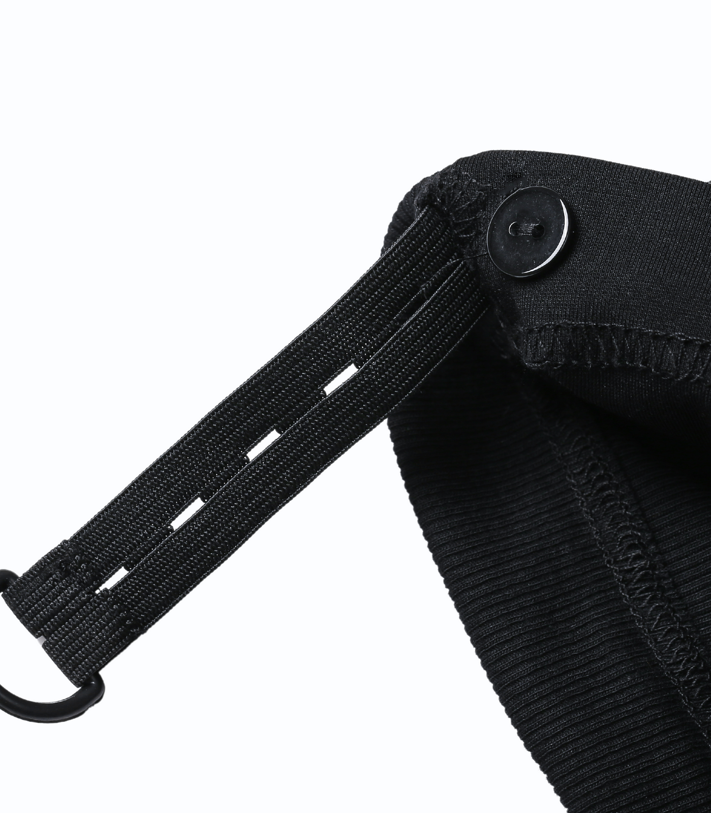 Close-up of a black strap attached to a black bag on a white background