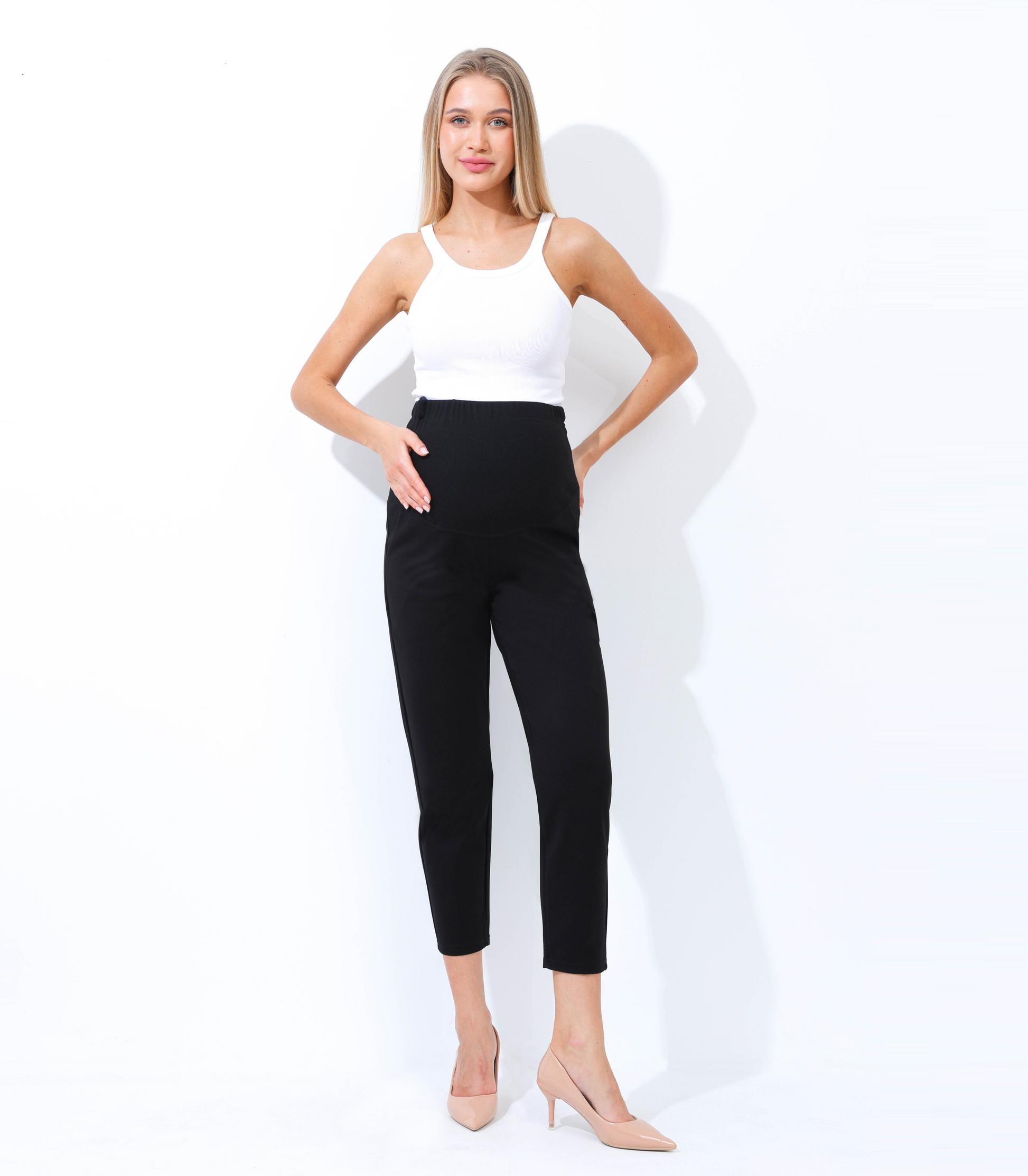 Woman wearing a white top and black pants on a white background