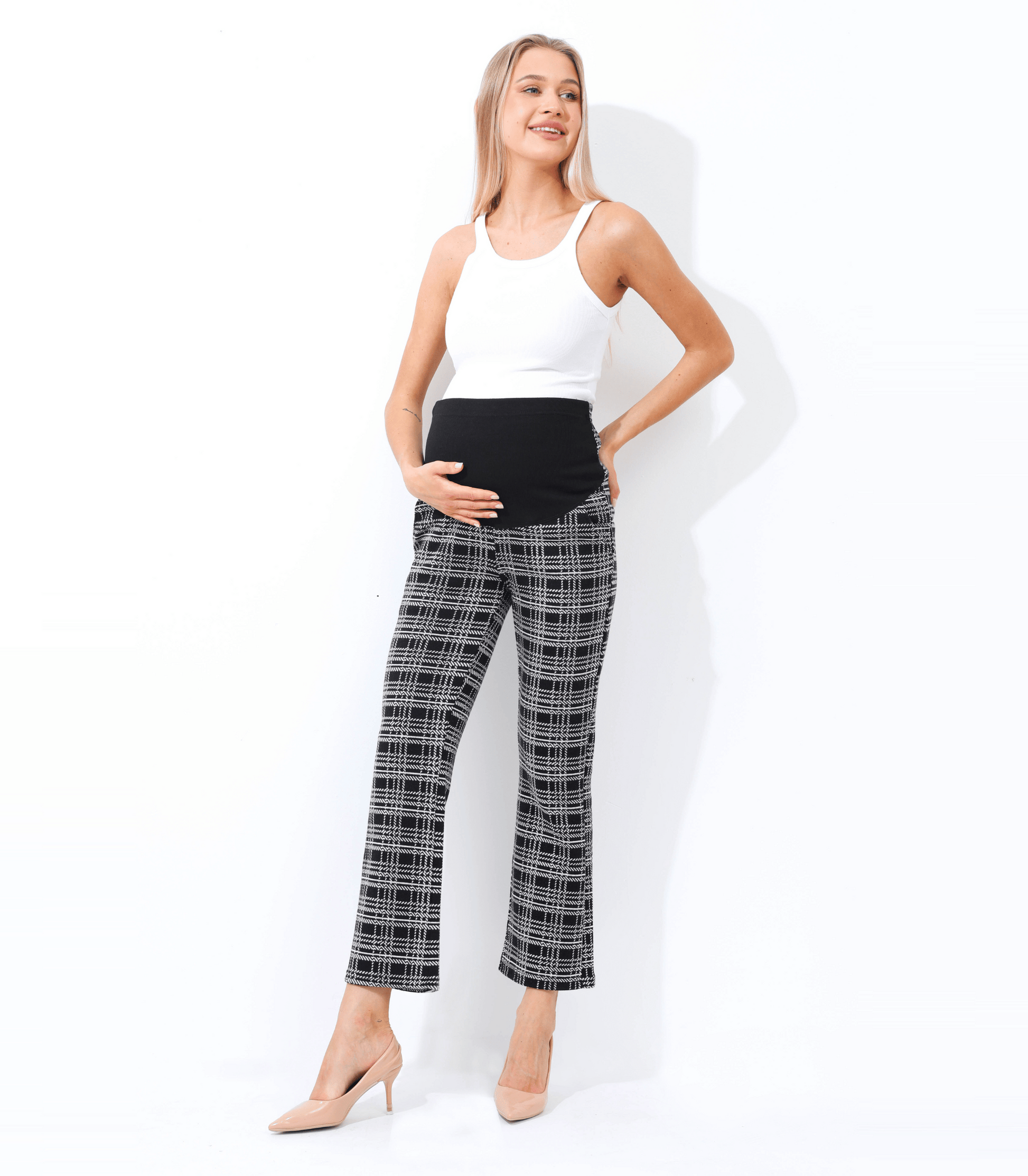 Woman wearing black plaid pants and a white top on a white background