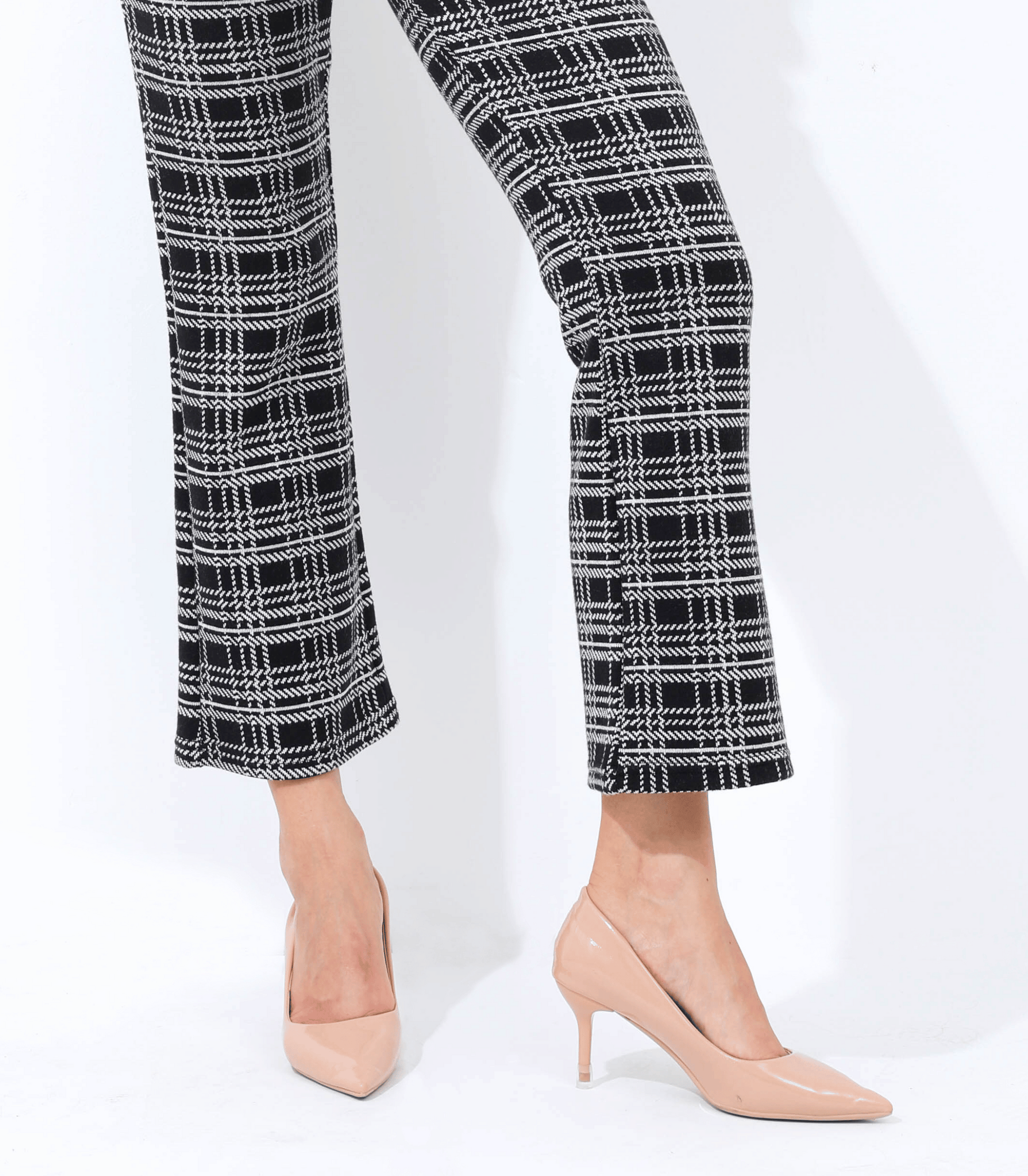 Black and white checkered pants with beige high-heeled shoes on a white background