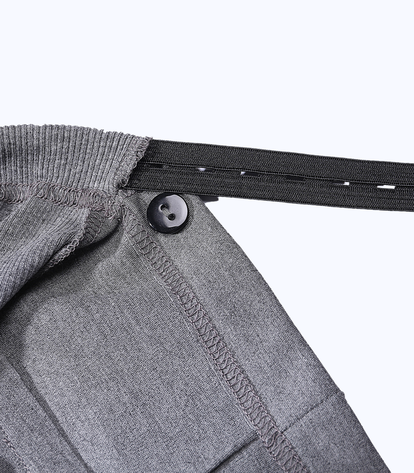 Close-up of a gray garment with a button and elastic band on a white background