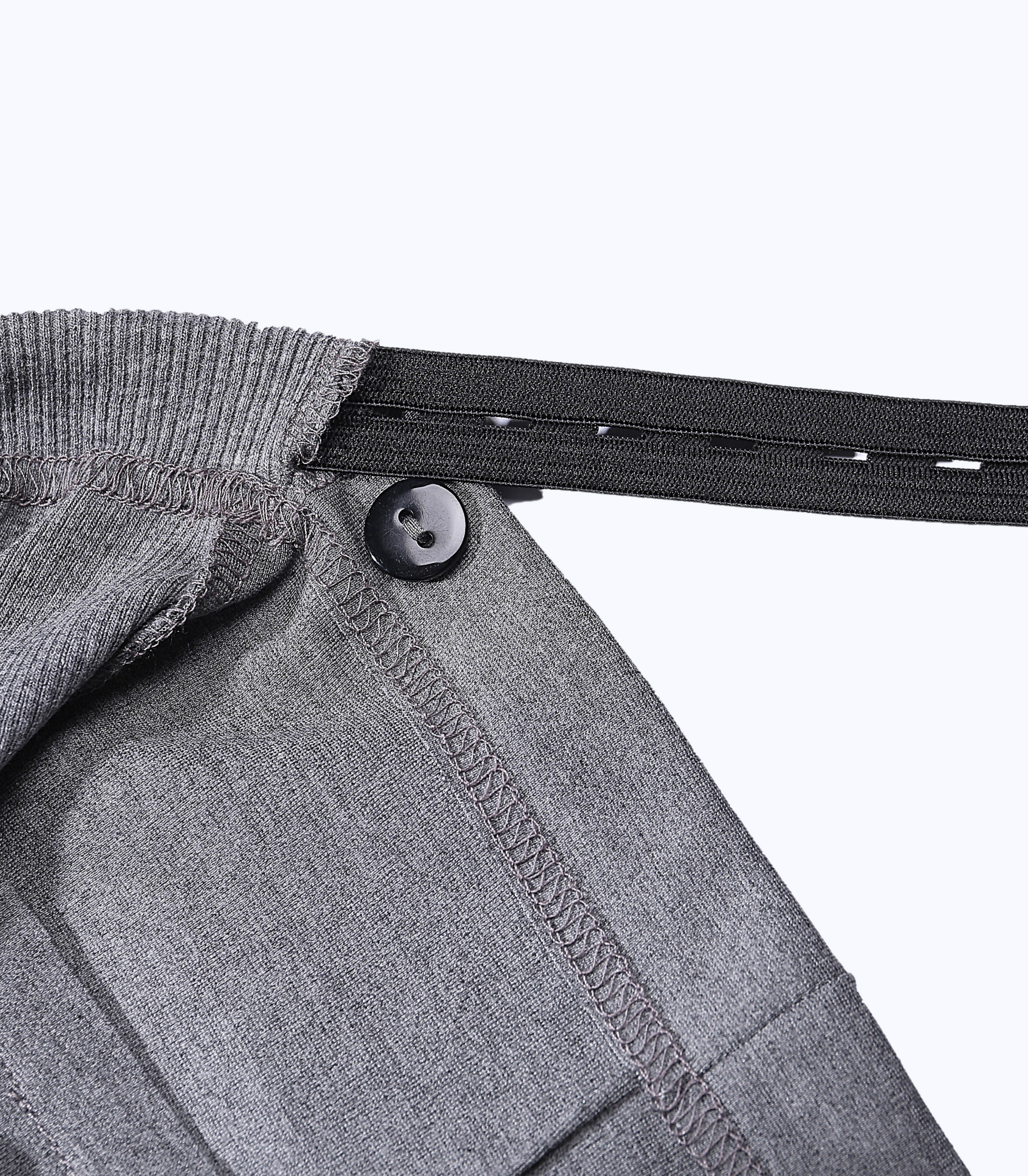 Close-up of a gray garment with a button and elastic band on a white background