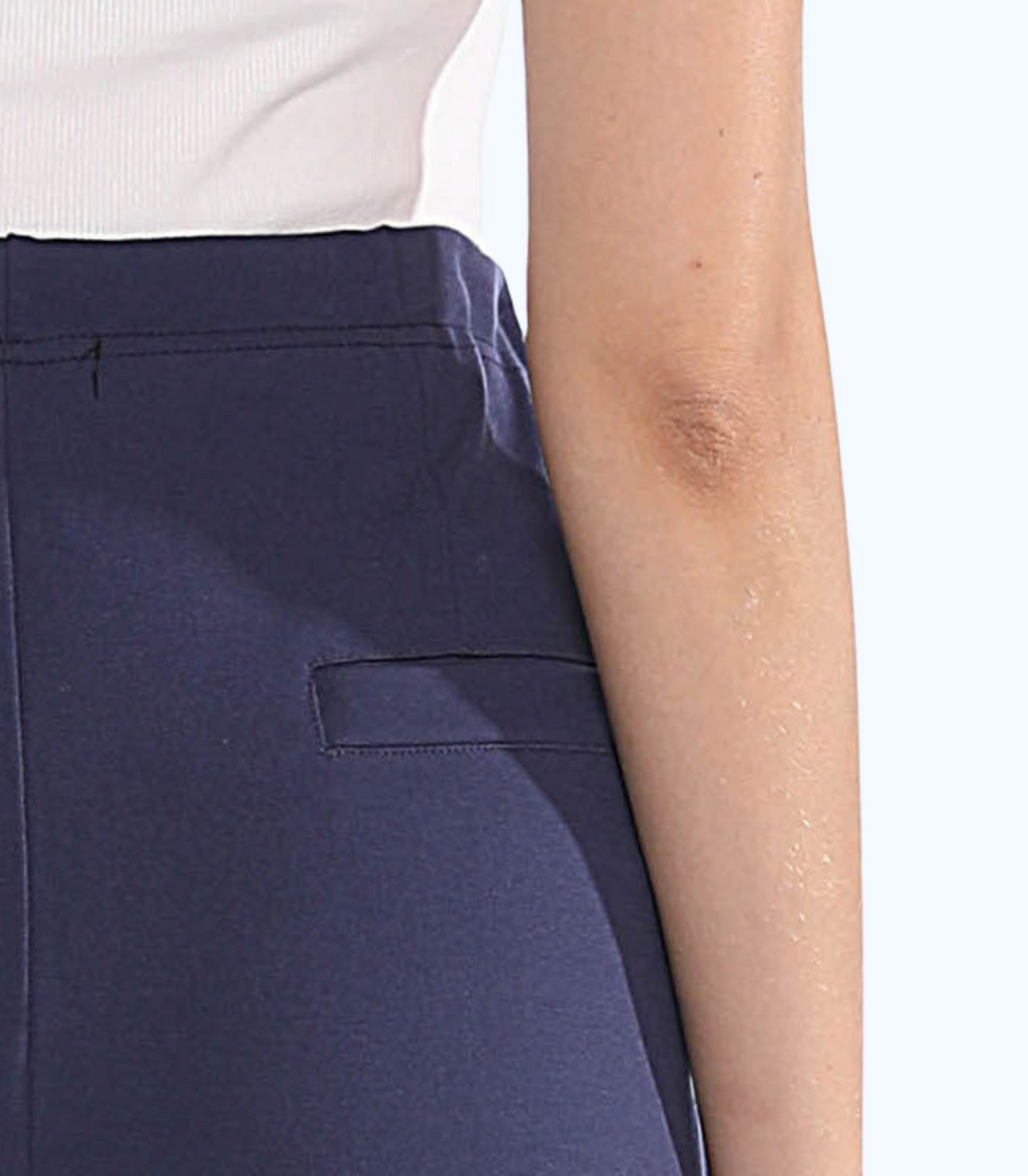 Navy blue pants with a white shirt on a light pink background
