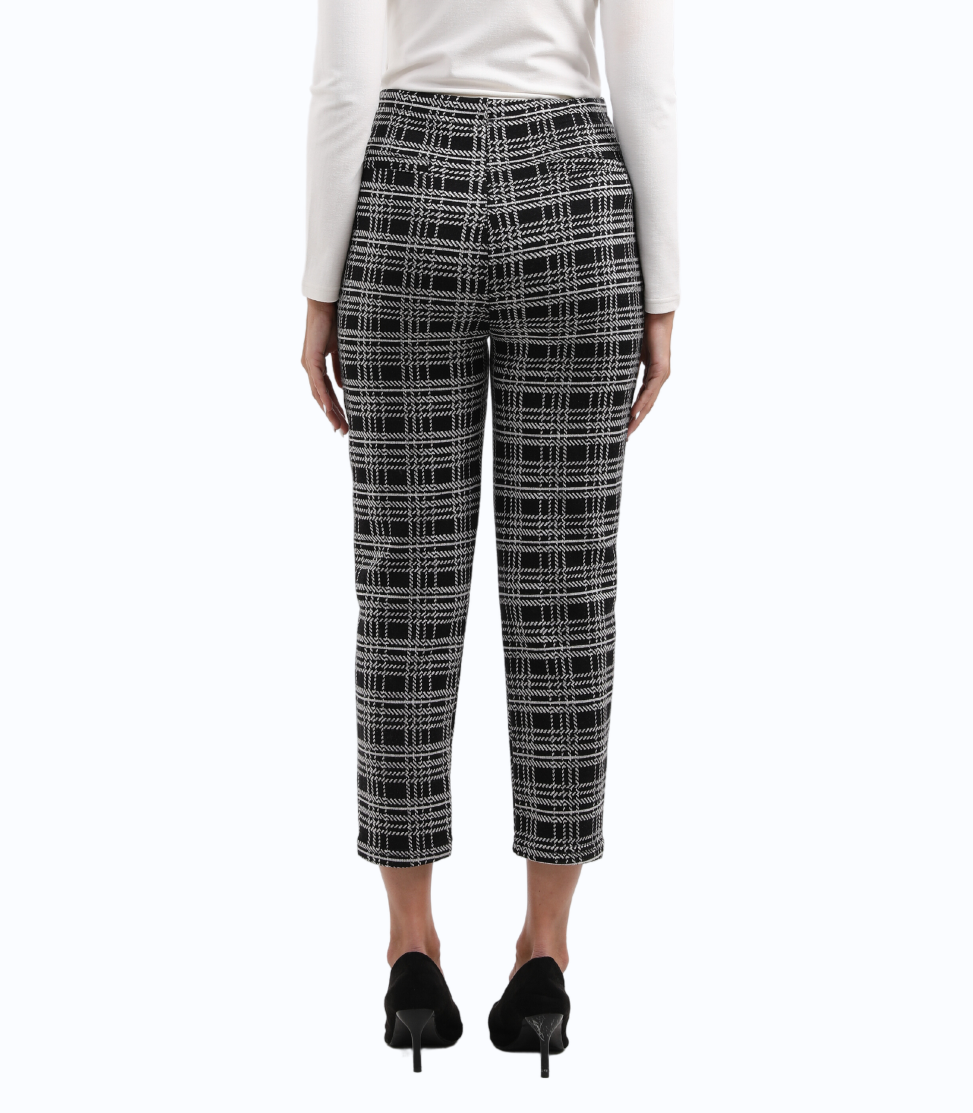 Person wearing black and white checkered pants on a white background