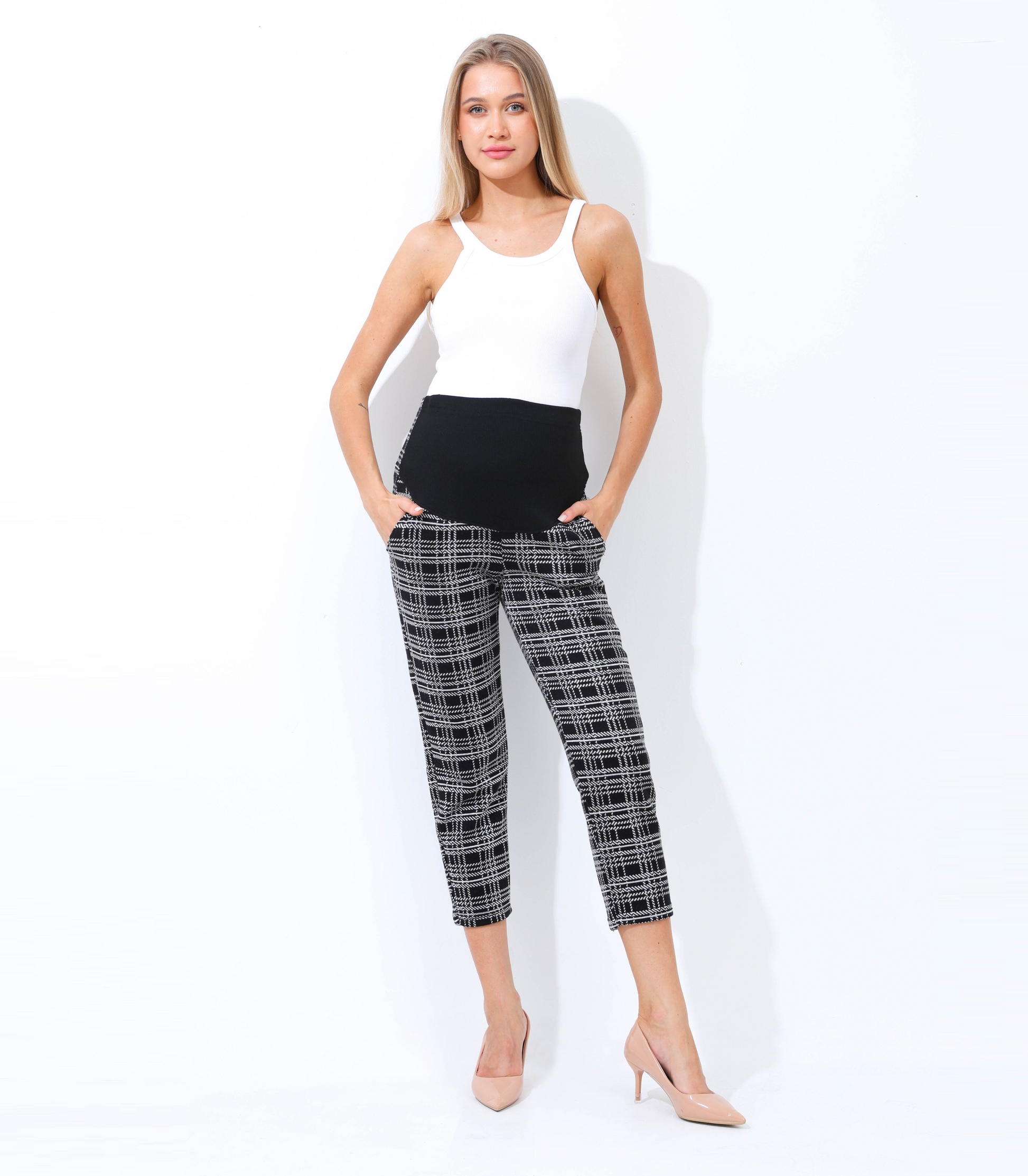 Woman wearing a white top and black plaid pants on a white background