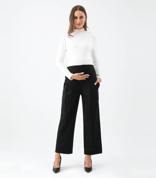 Woman wearing a white top and black wide-leg pants on a white background