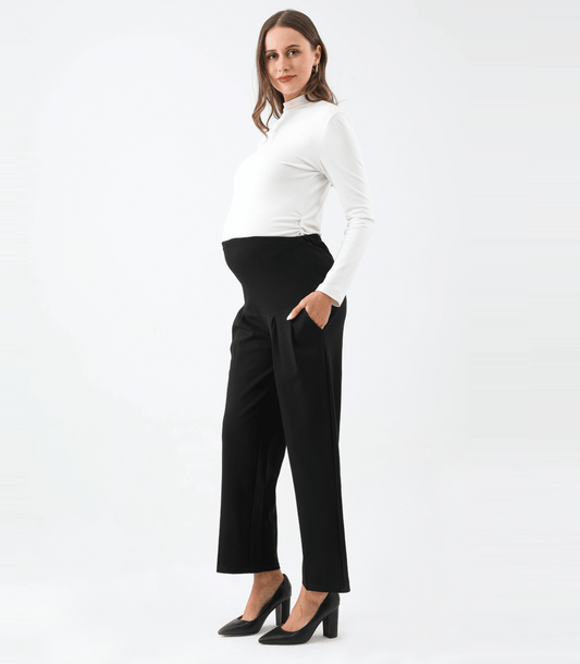 Woman wearing a white top and black pants on a white background