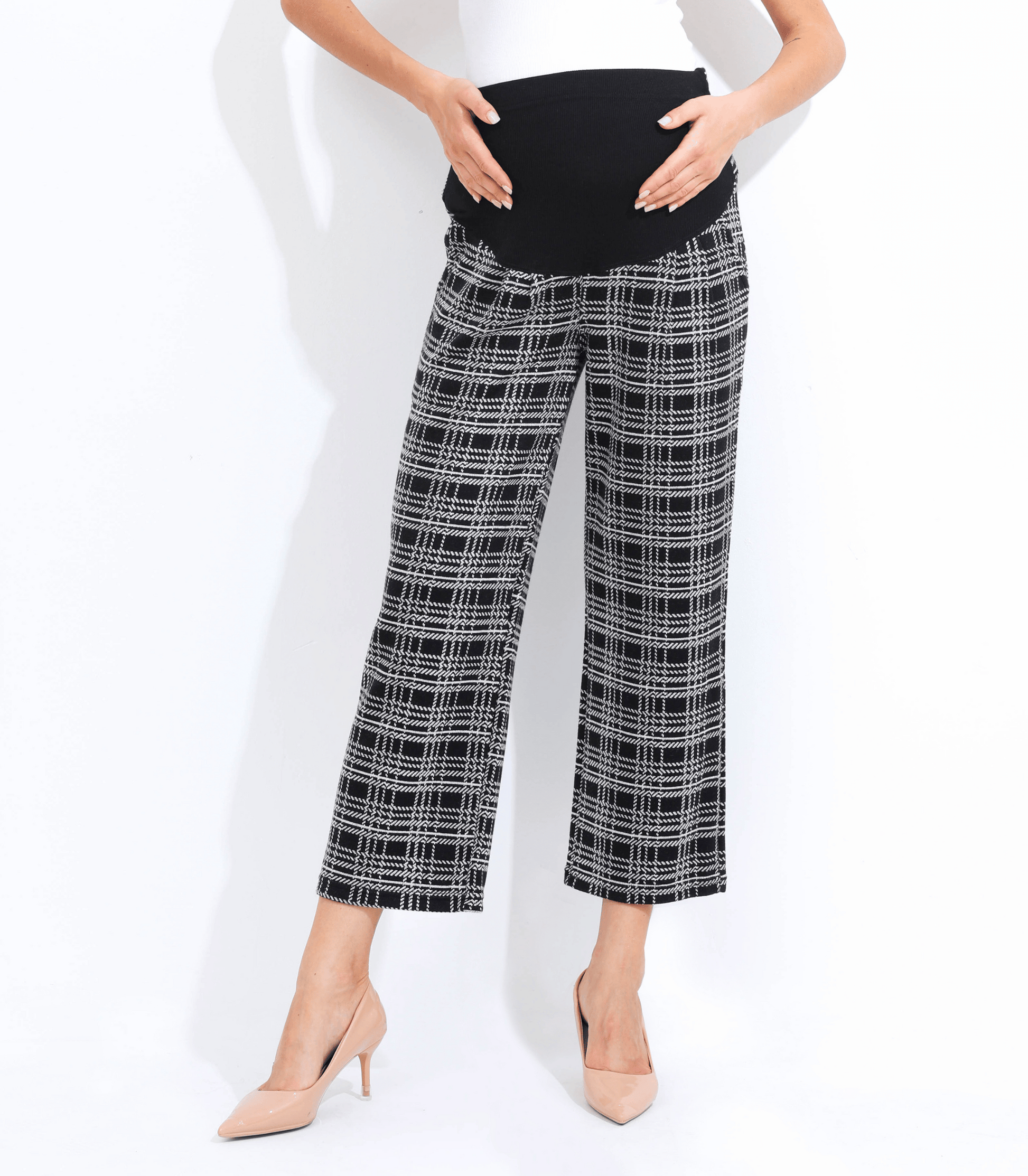 Person wearing black and white checkered pants on a white background