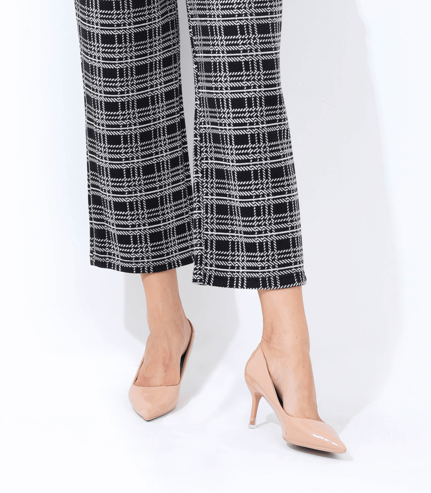 Black and white checkered pants with beige high-heeled shoes on a white background