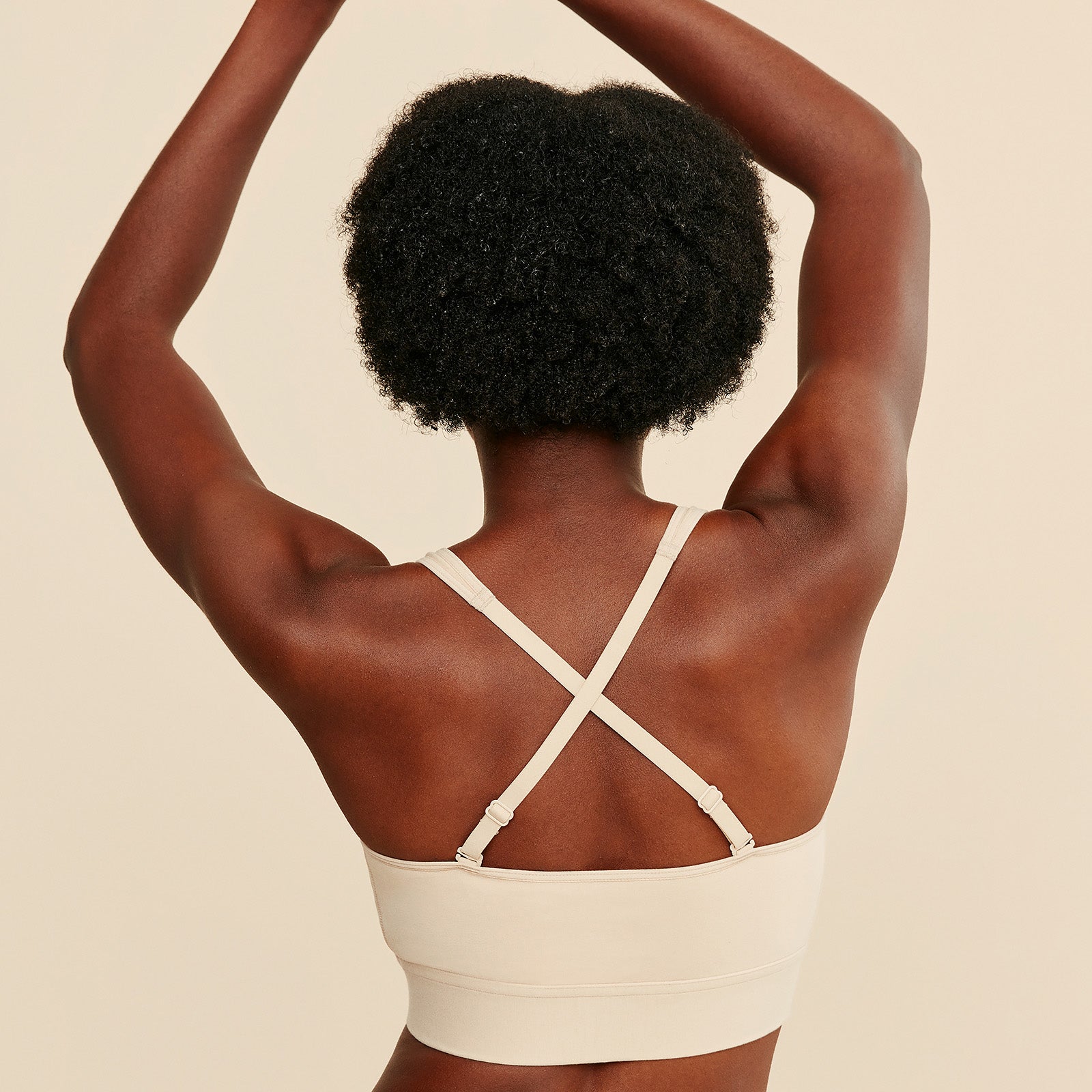 Beige cotton bralette with crisscross back straps and front zipper closure