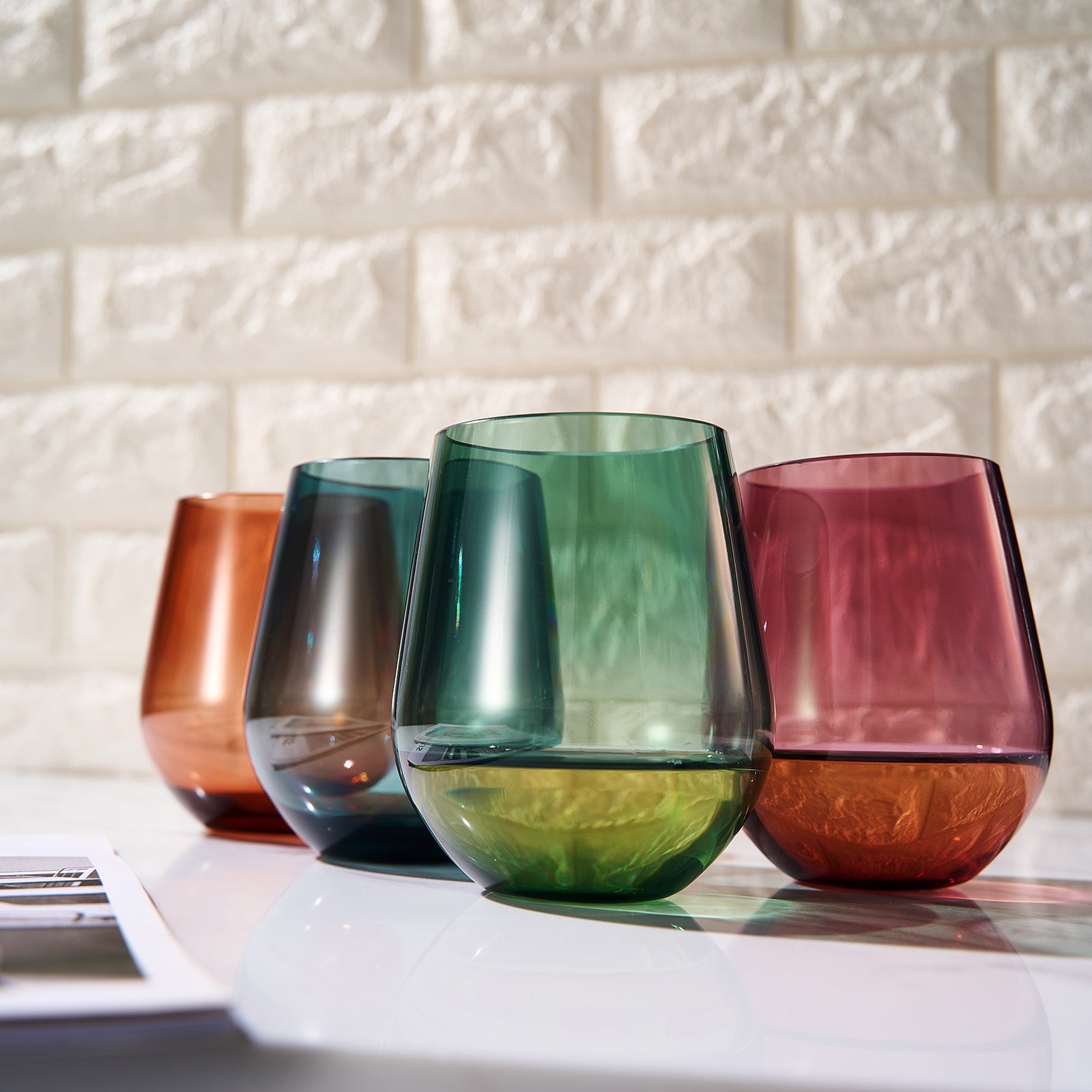 Set of 4 stemless acrylic wine glasses in green, red, amber, and blue.