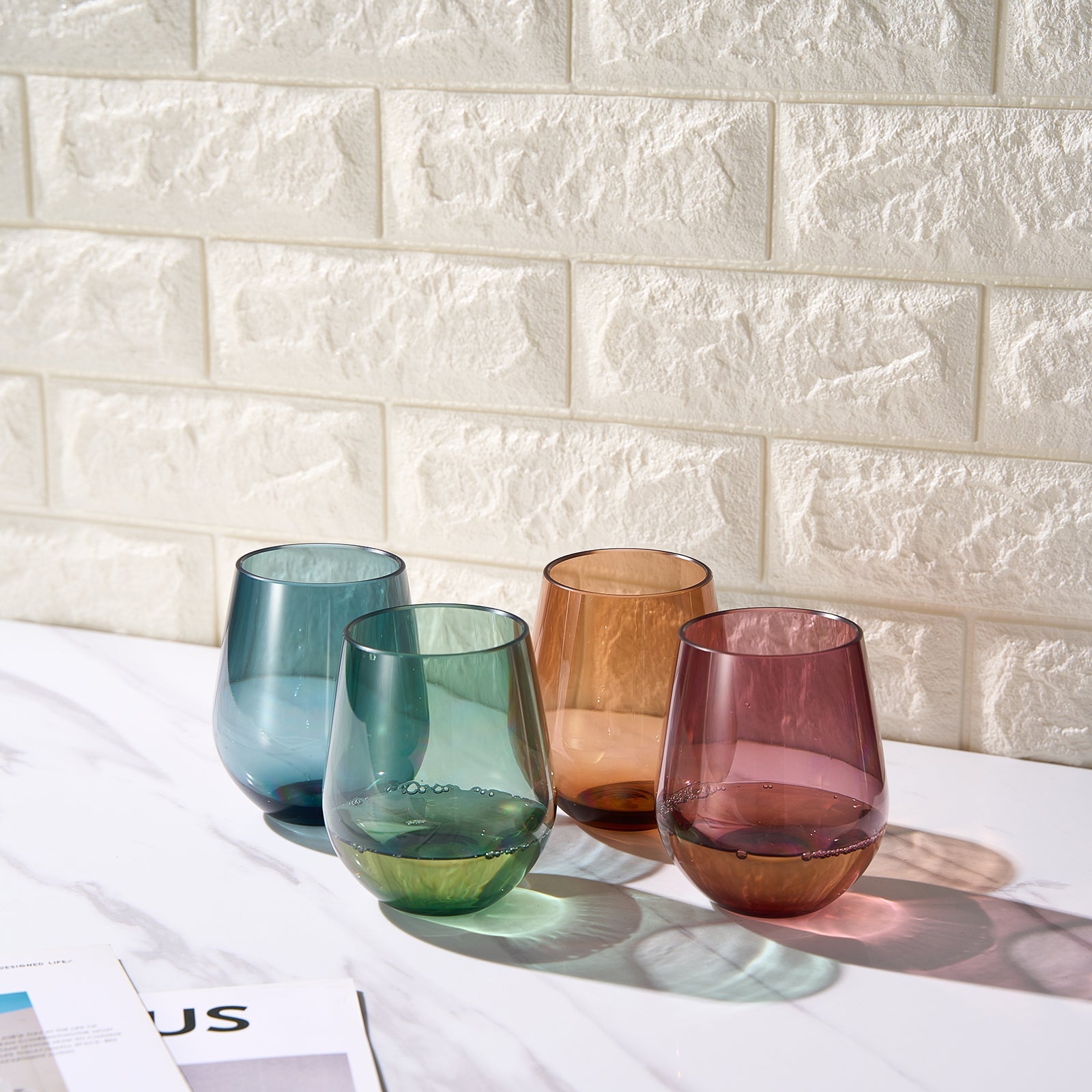 Set of 4 stemless acrylic wine glasses in teal, green, amber, and burgundy.