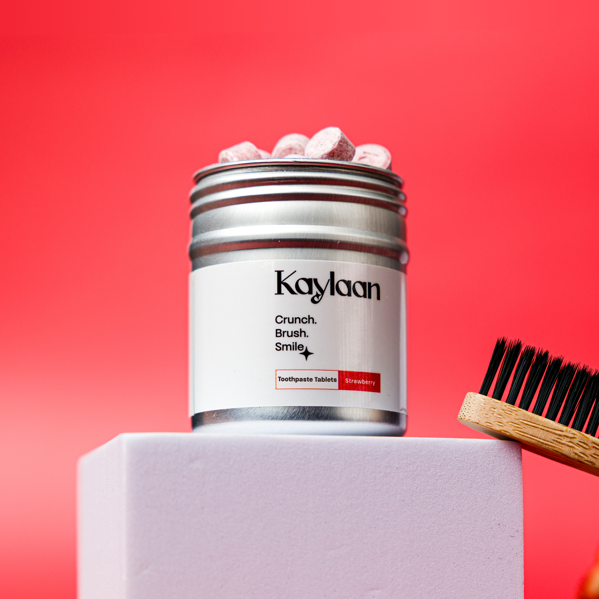 Non-fluoride strawberry toothpaste tablets jar with toothbrush and tablet pieces