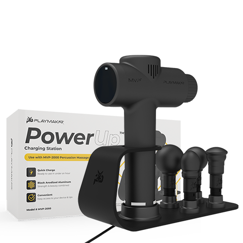 Black charging station with four massage heads, shown with included product box