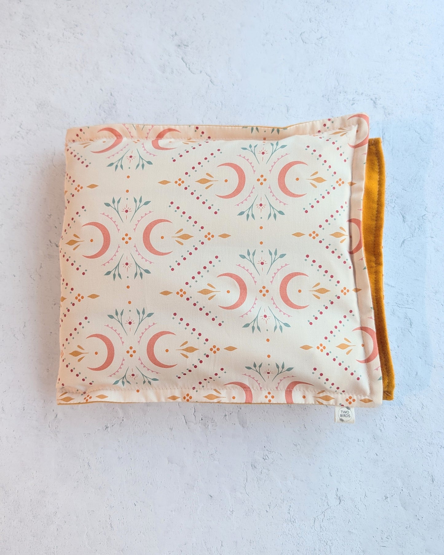 Weighted heating pad with crescent-floral print and mustard flannel backing
