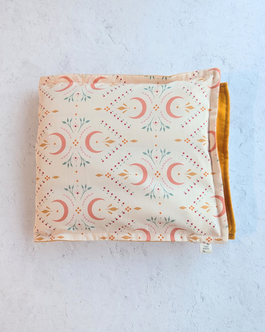Weighted heating pad with crescent-floral print and mustard flannel backing